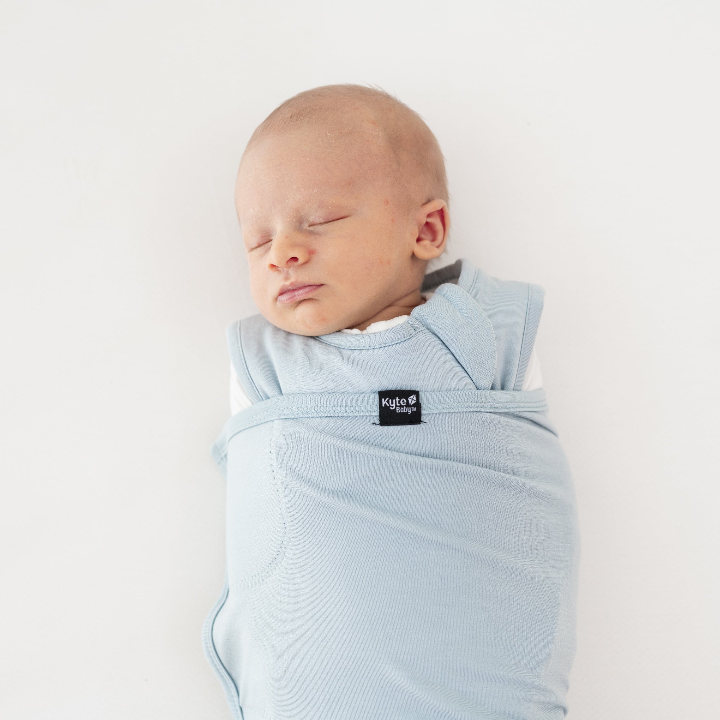Close up of sleeping baby swaddled in the Sleep Bag Swaddler in Fog 1.0