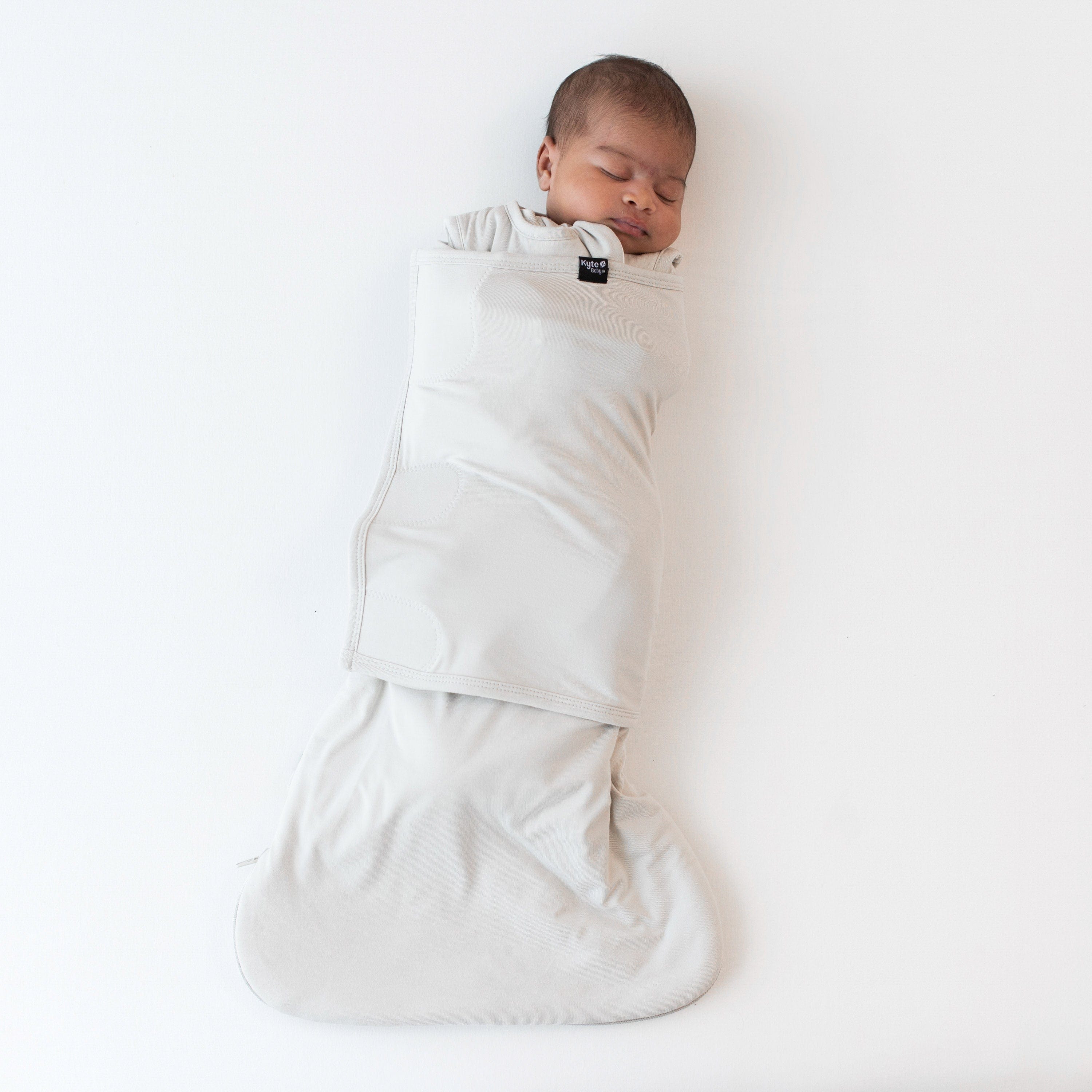 Sleeping baby swaddled in the Sleep Bag Swaddler in Oat 1.0