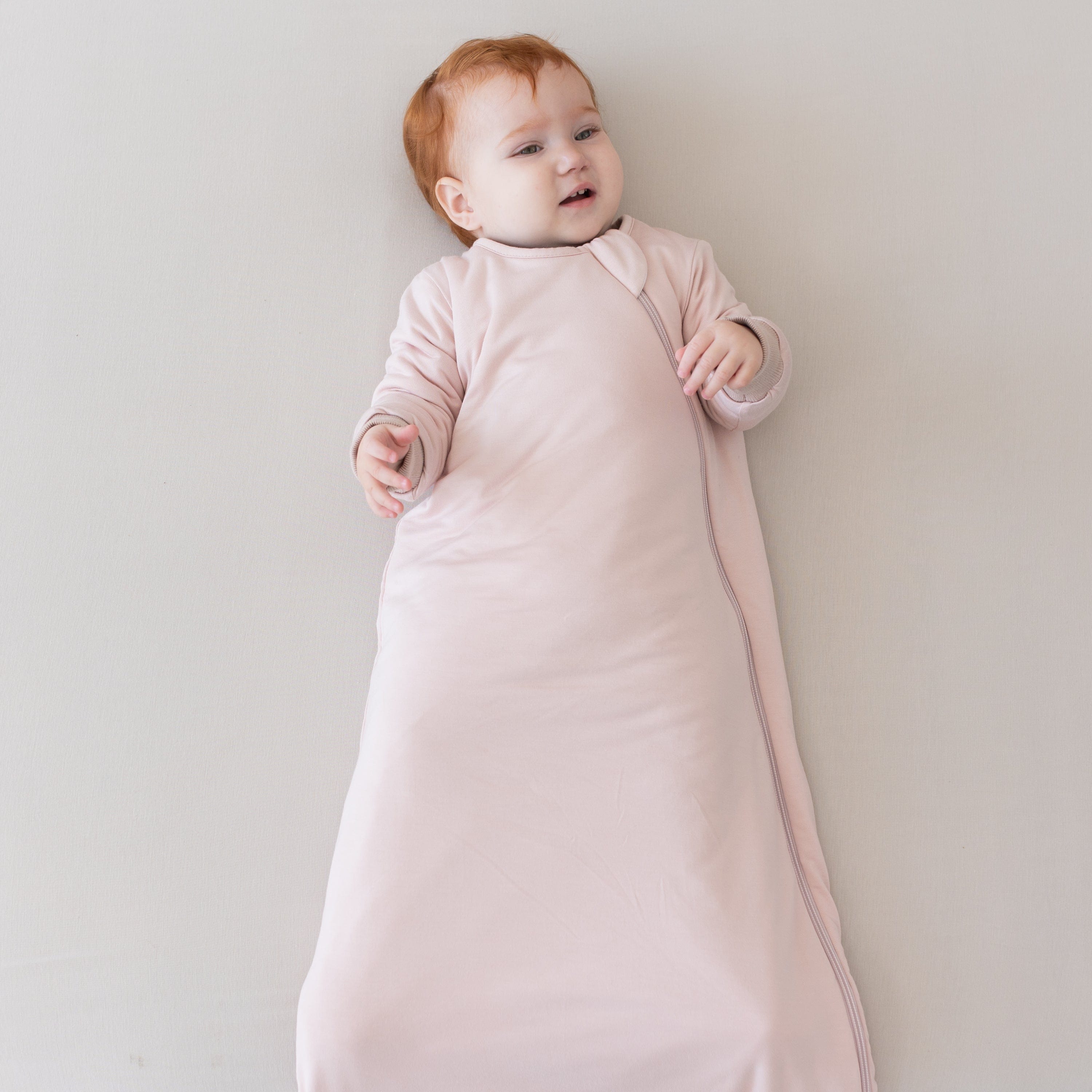 Baby wearing long sleeve Kyte Baby Slumber Bag in Blush