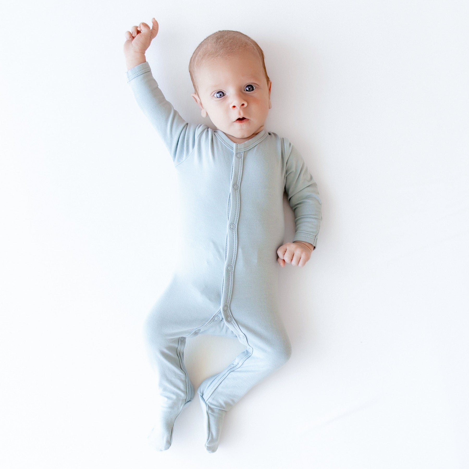 Newborn wearing Kyte Baby Footie in Fog