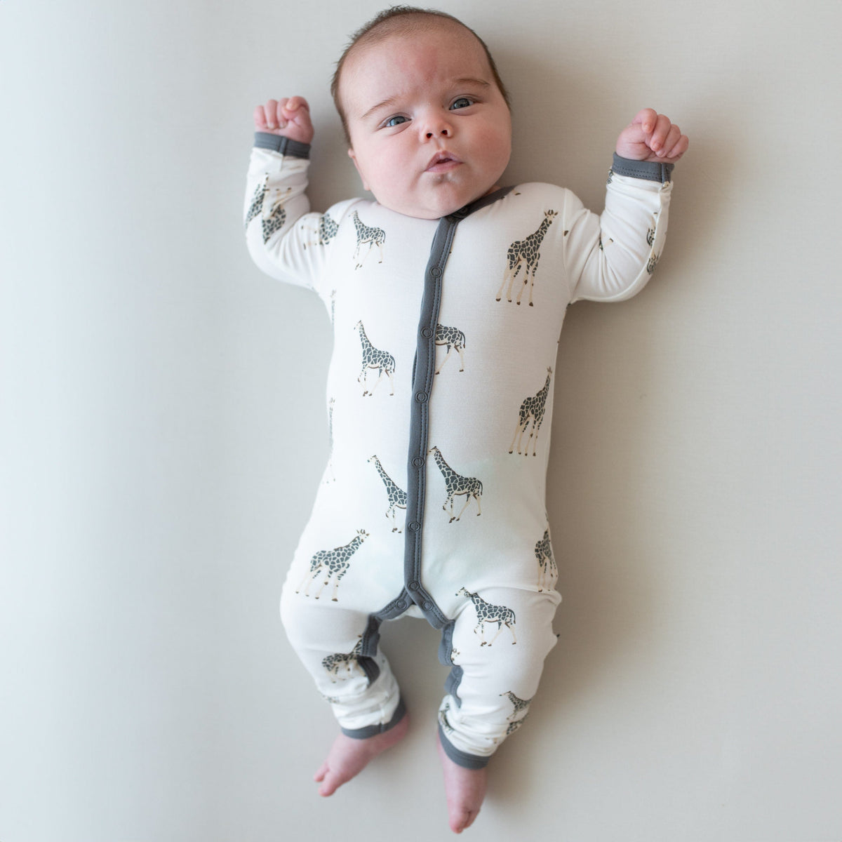 Infant wearing Kyte Baby Romper in Giraffe