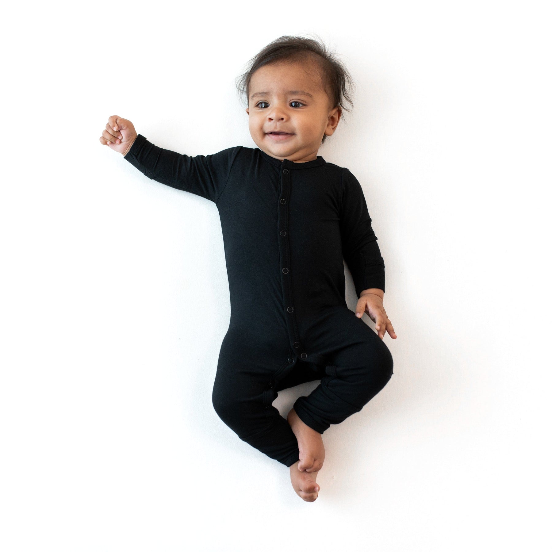 Child wearing long sleeve Kyte Baby Romper with snaps in Midnight