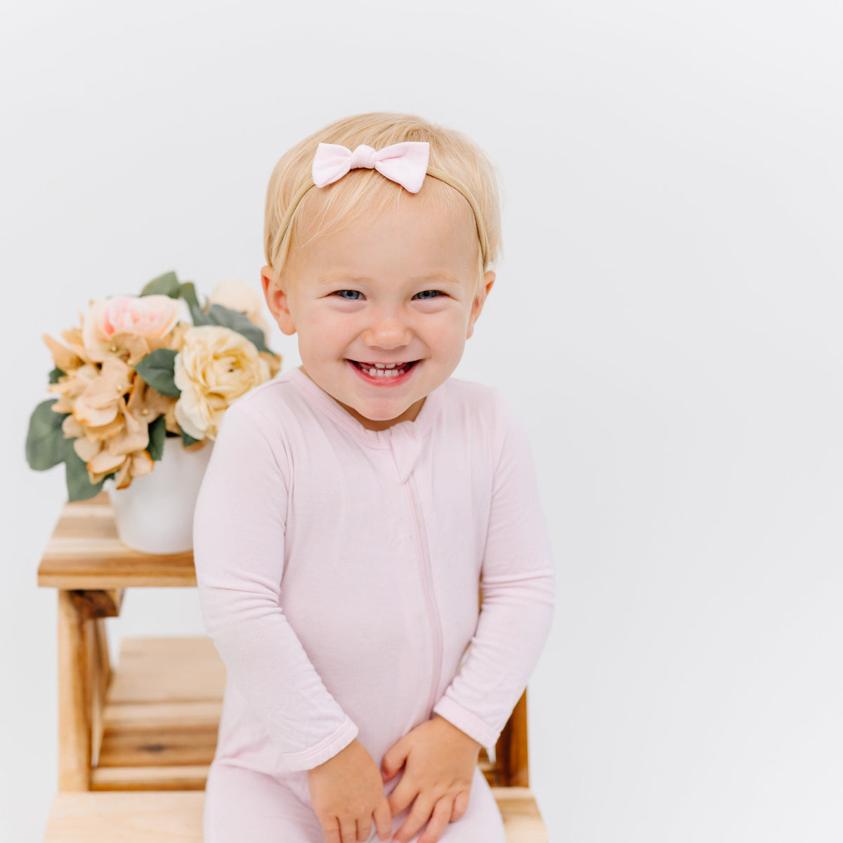 Infant wearing Kyte Baby Tiny Nylon Bow in Sakura