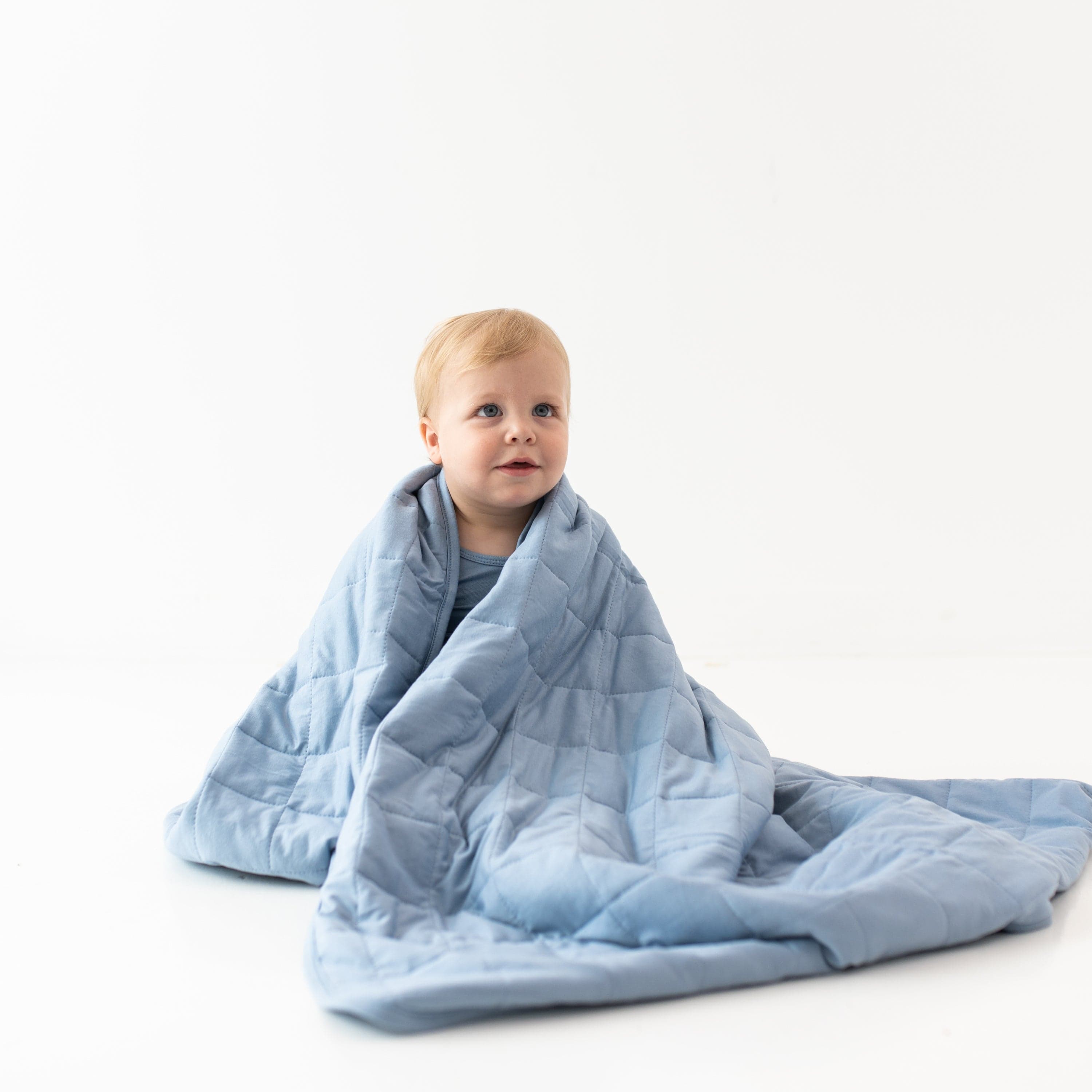 Child wrapped in Kyte Baby TOG 2.5 Toddler Blanket in Slate