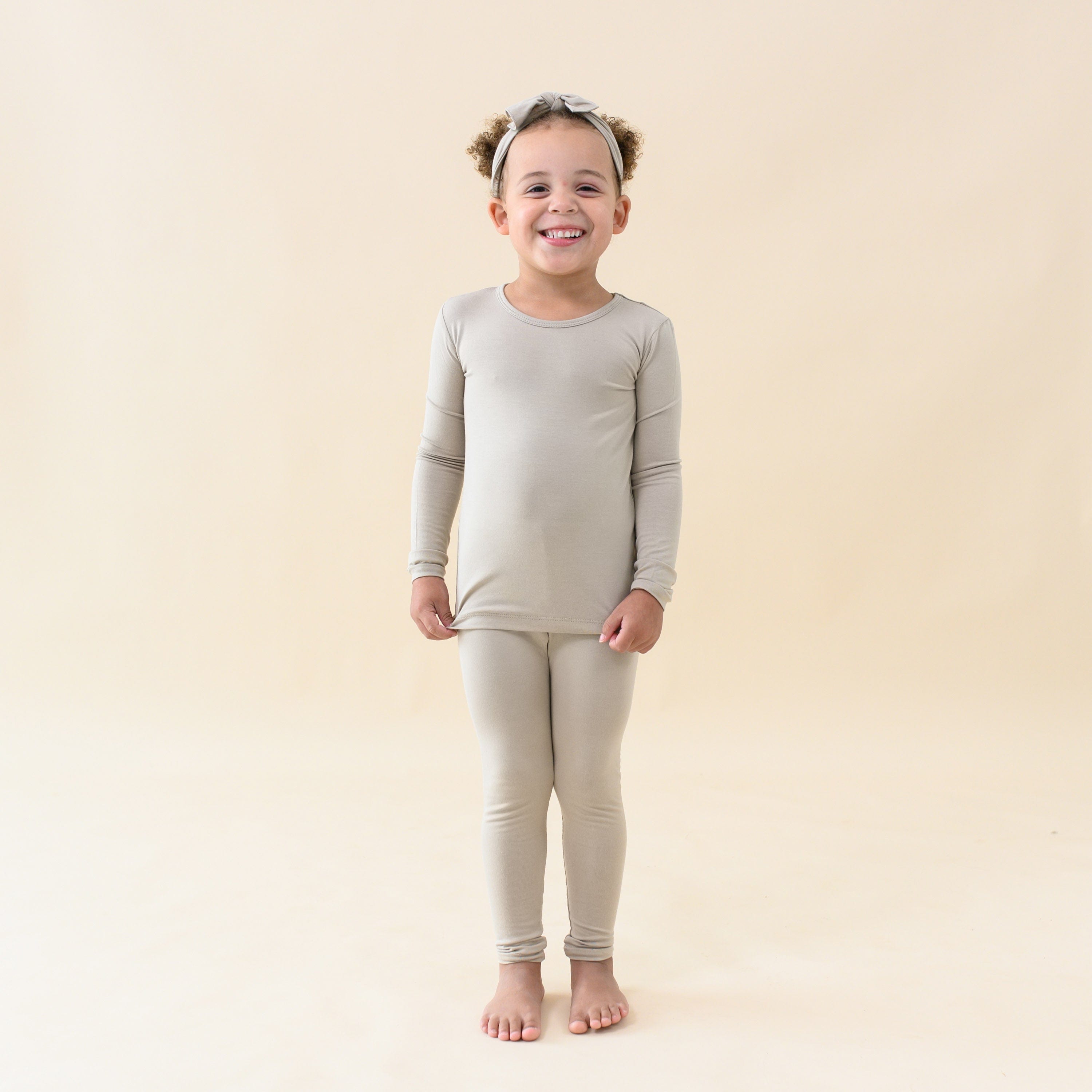 Toddler wearing Kyte Baby Long Sleeve Pajamas in Almond