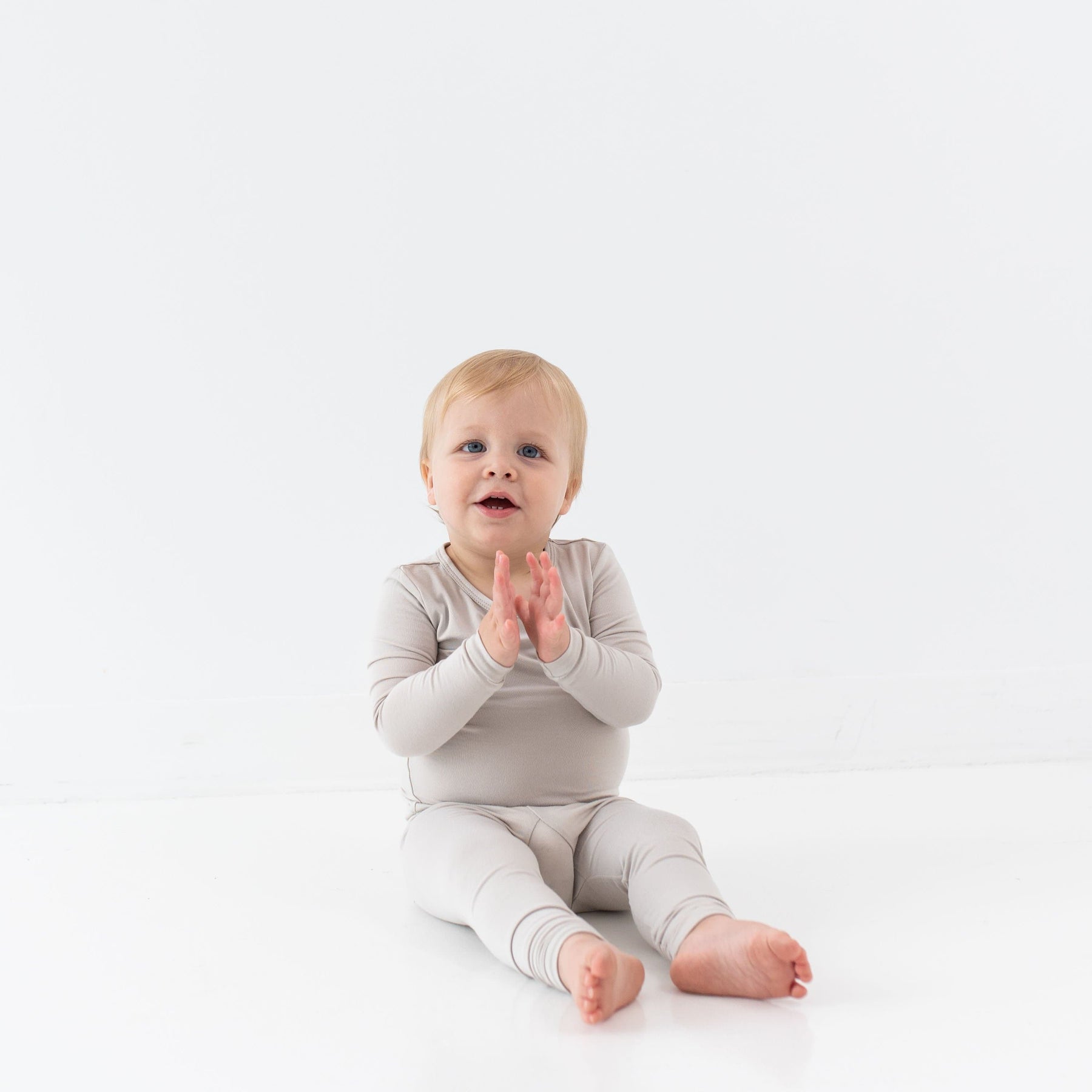 Toddler wearing two piece Kyte Baby Long Sleeve Pajamas in Oat