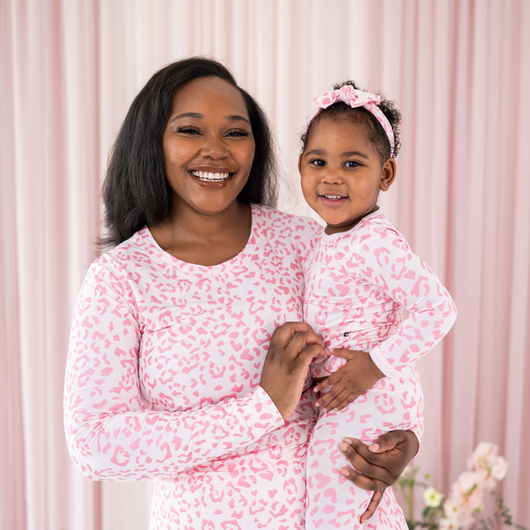 Mom and child wearing Kyte Baby matching pajama sets in Sakura Leopard