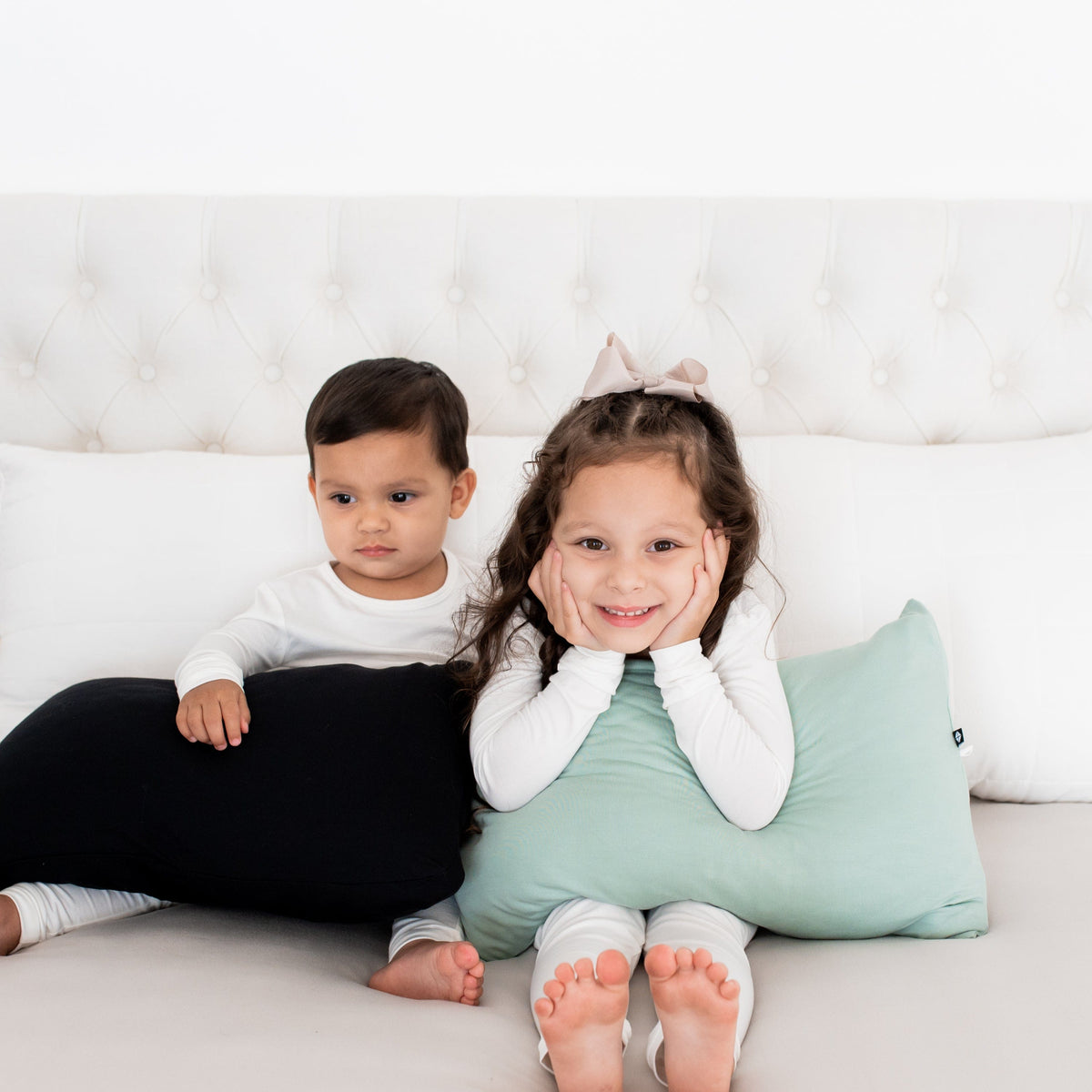 Siblings holding Kyte Baby Toddler Pillowcases