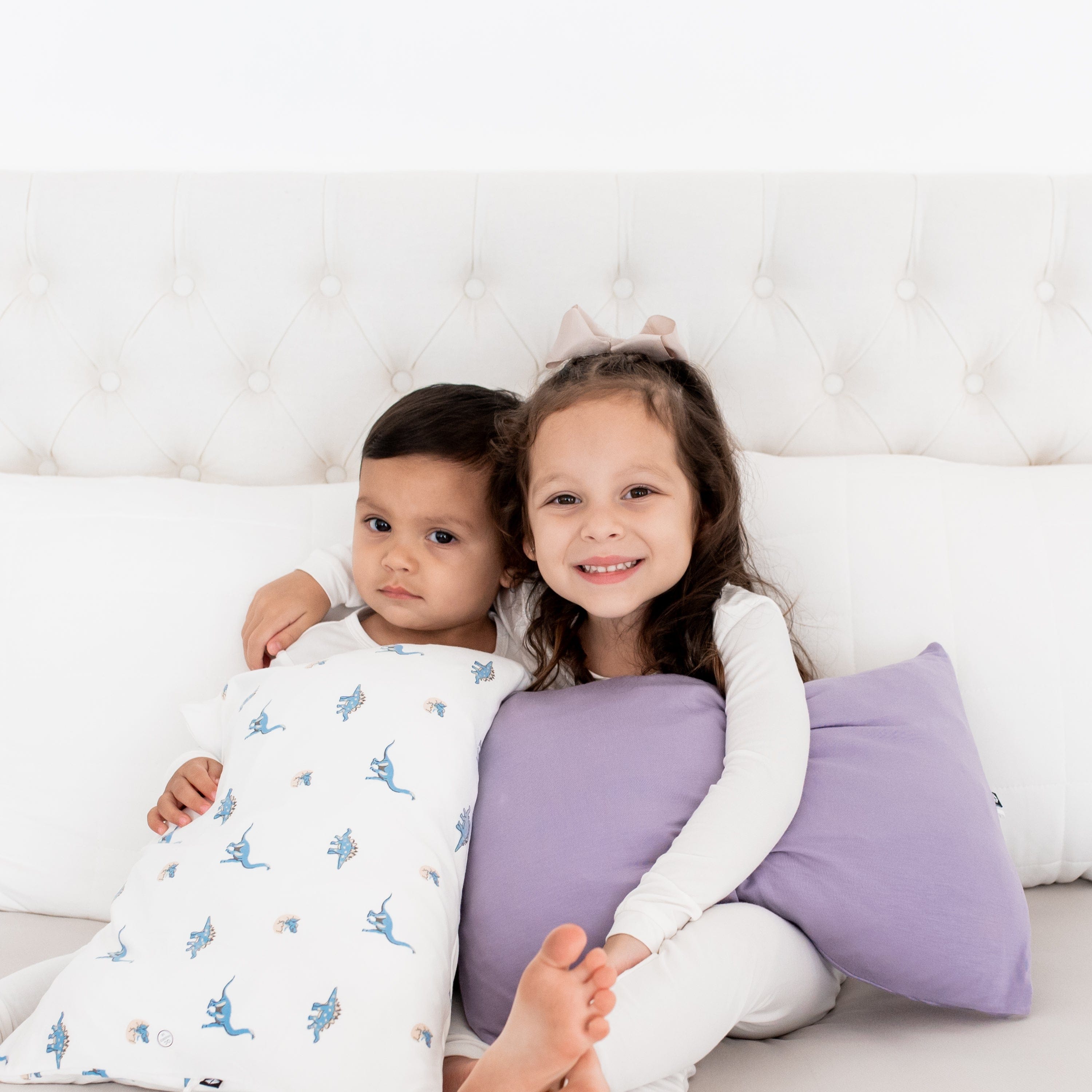 Siblings holding Kyte Baby Toddler Pillowcases
