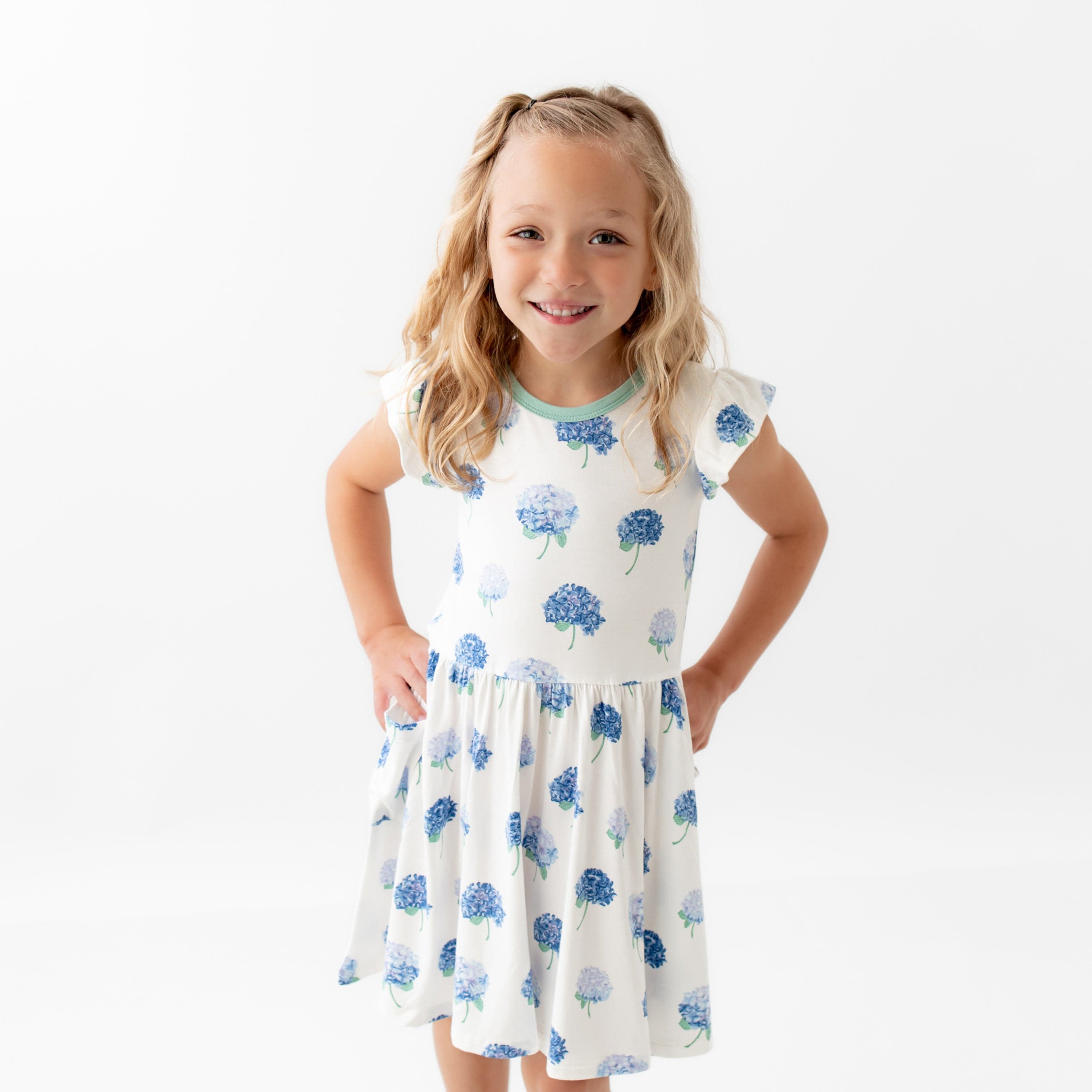 Girl wearing Kyte Baby Pocket Dress in Hydrangea