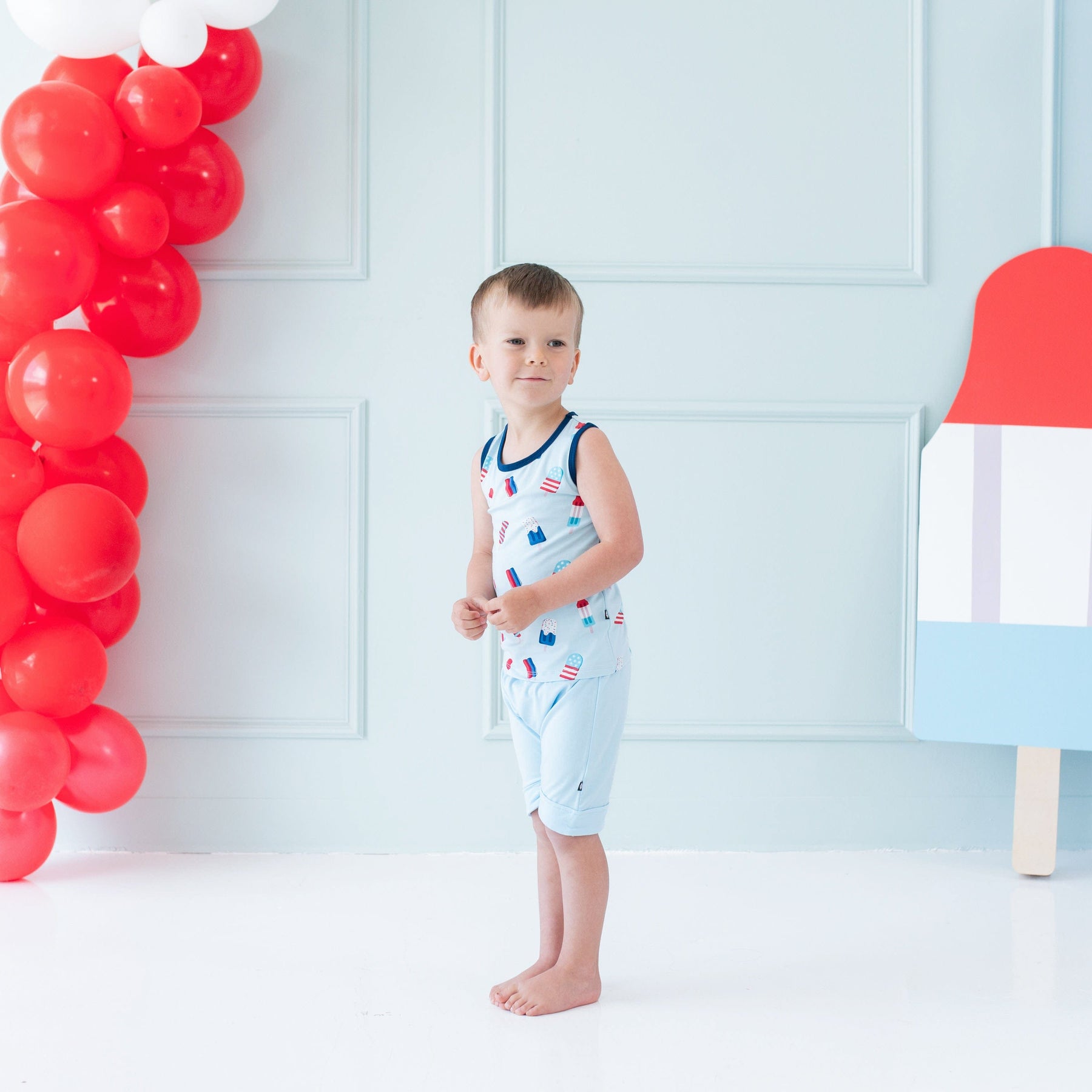 Boy wearing Kyte Baby Toddler Tank Top in Popsicle