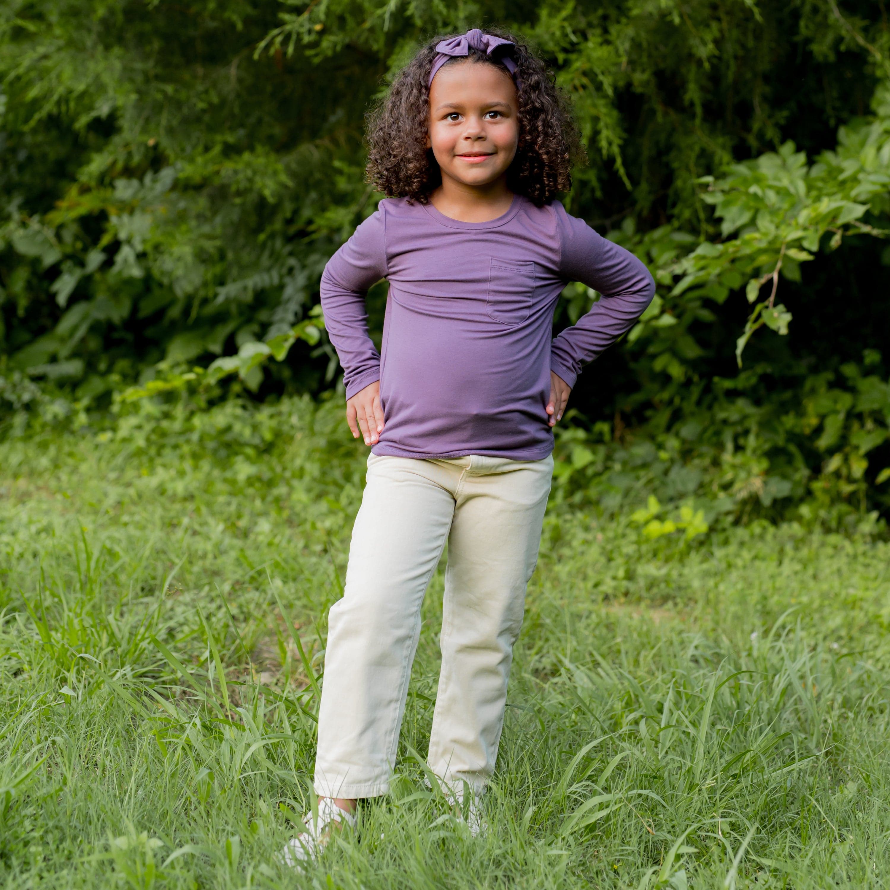 Girl wearing Kyte Baby bamboo Long Sleeve Toddler Crew Neck Tee in Currant