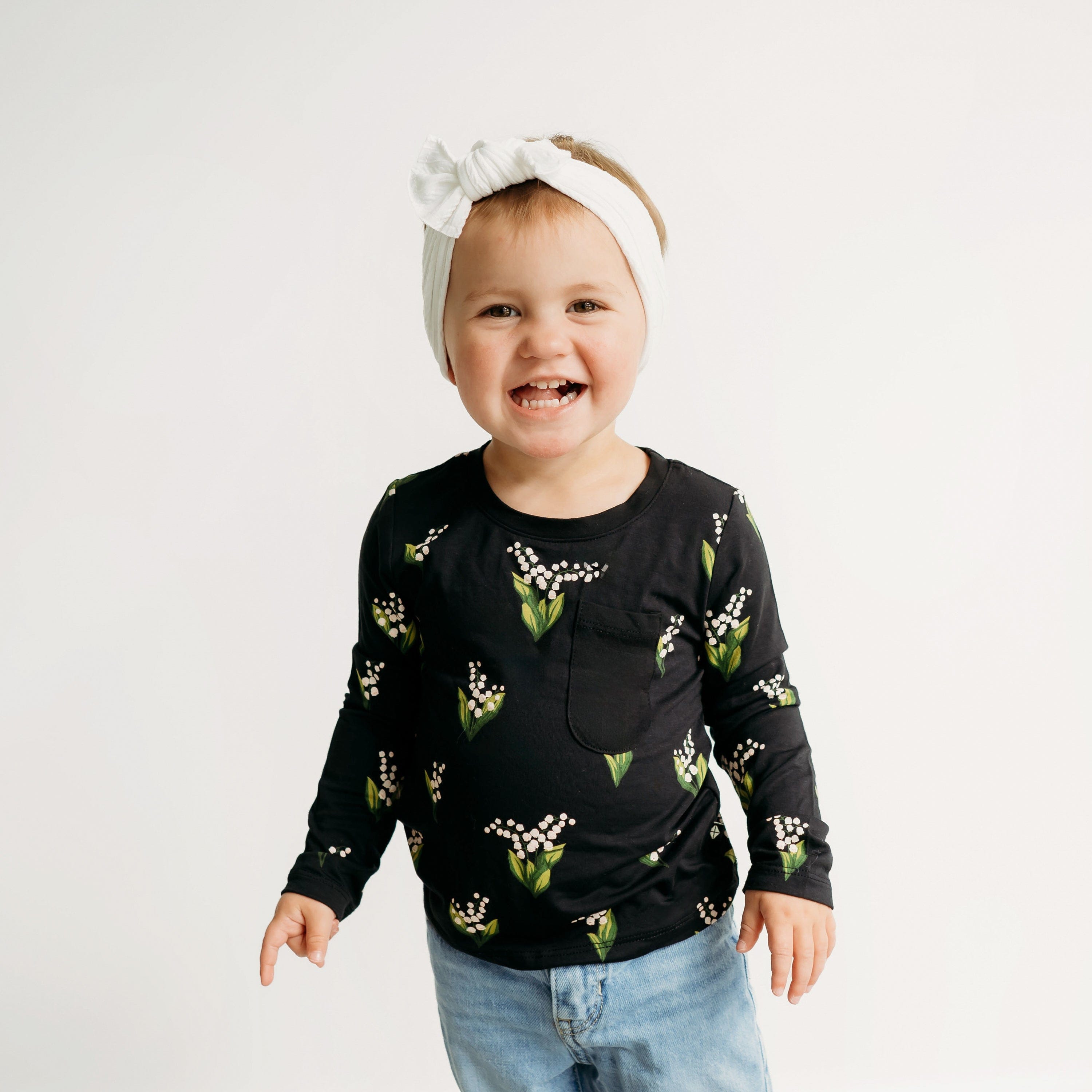 Girl wearing Kyte Baby bamboo Long Sleeve Toddler Crew Neck Tee in Midnight Lily