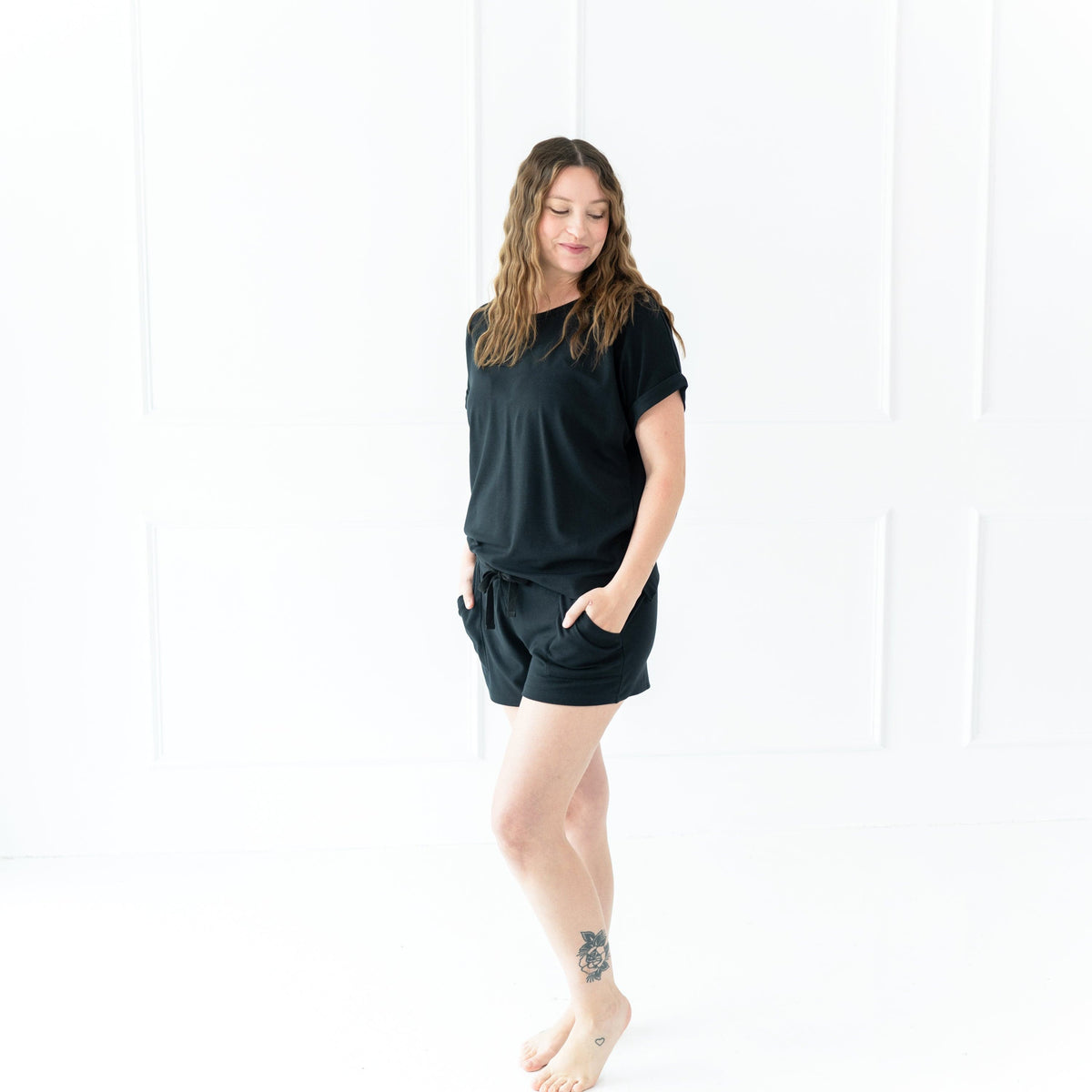 Woman wearing Kyte Baby Women's Bamboo Jersey Rolled Sleeve Tee with Boat Neckline in Midnight Black