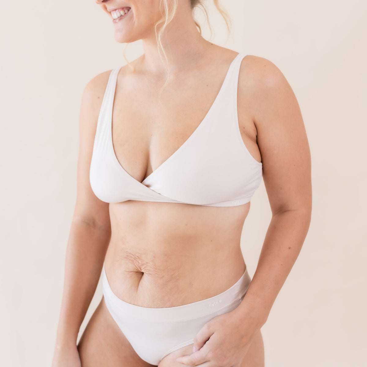 Woman wearing Kyte Baby Women's Cross Front Bralette and Matching Underwear in Blonde