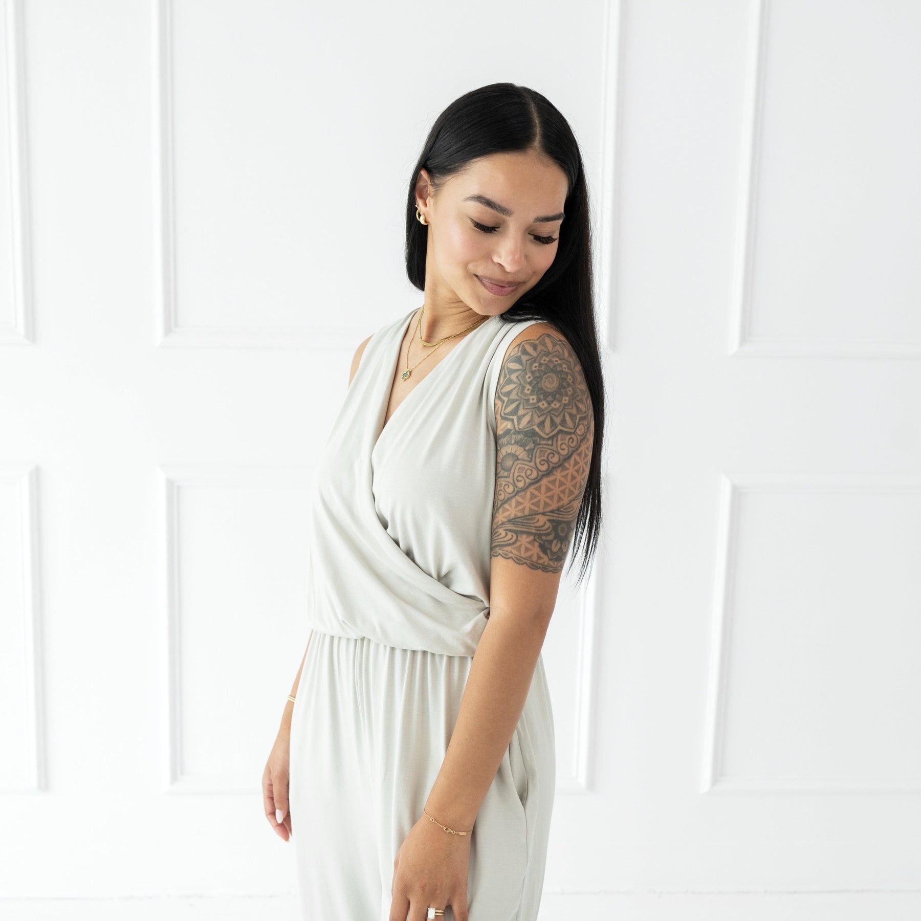 Woman wearing Kyte Baby bamboo sleeveless jumpsuit in Oat