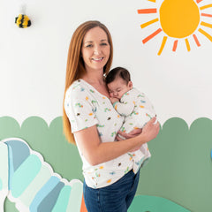 Woman wearing Kyte Baby Women's Relaxed Fit V-Neck in The Very Hungry Caterpillar™ and Friends with Infant in matching footie pajamas