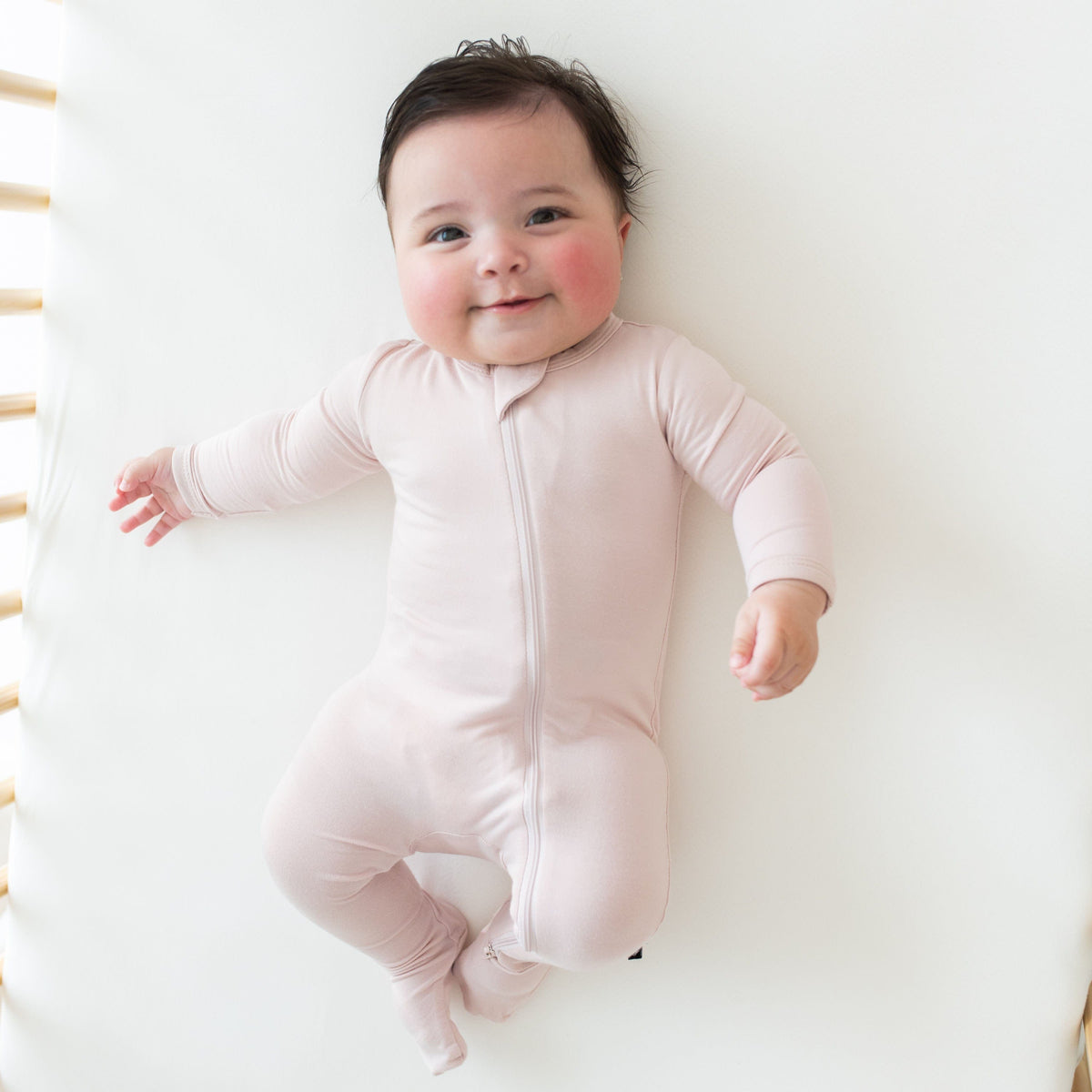 Baby wearing Kyte Baby Zippered Footie in Blush