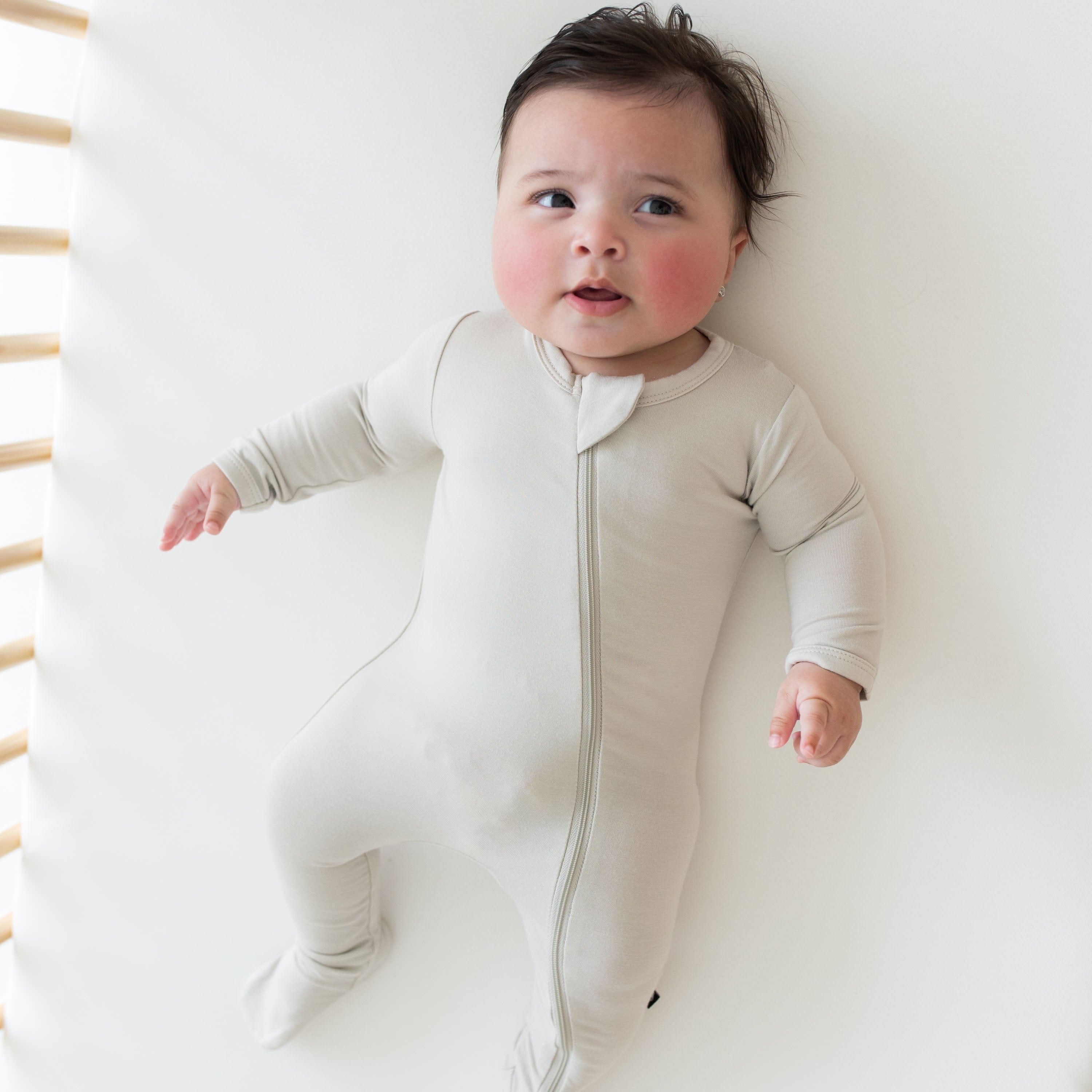 Baby wearing Kyte Baby breathable bamboo Zippered Footie in Oat