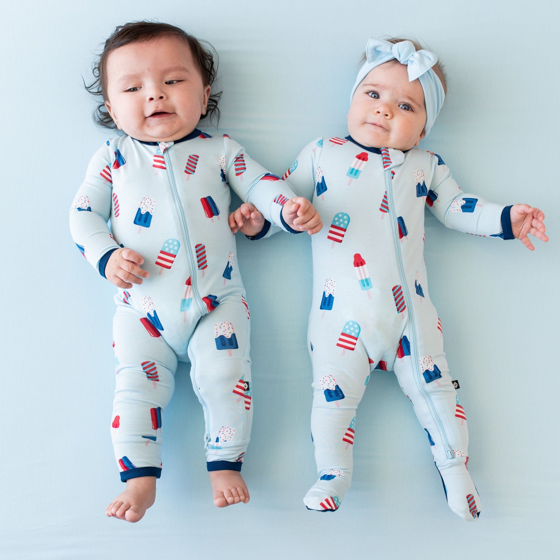 Babies wearing Kyte Baby matching pajamas in Popsicle print