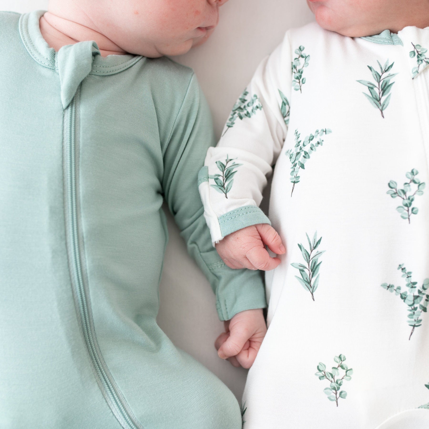 Babies sleeping in Kyte Baby bamboo zippered footie pajamas