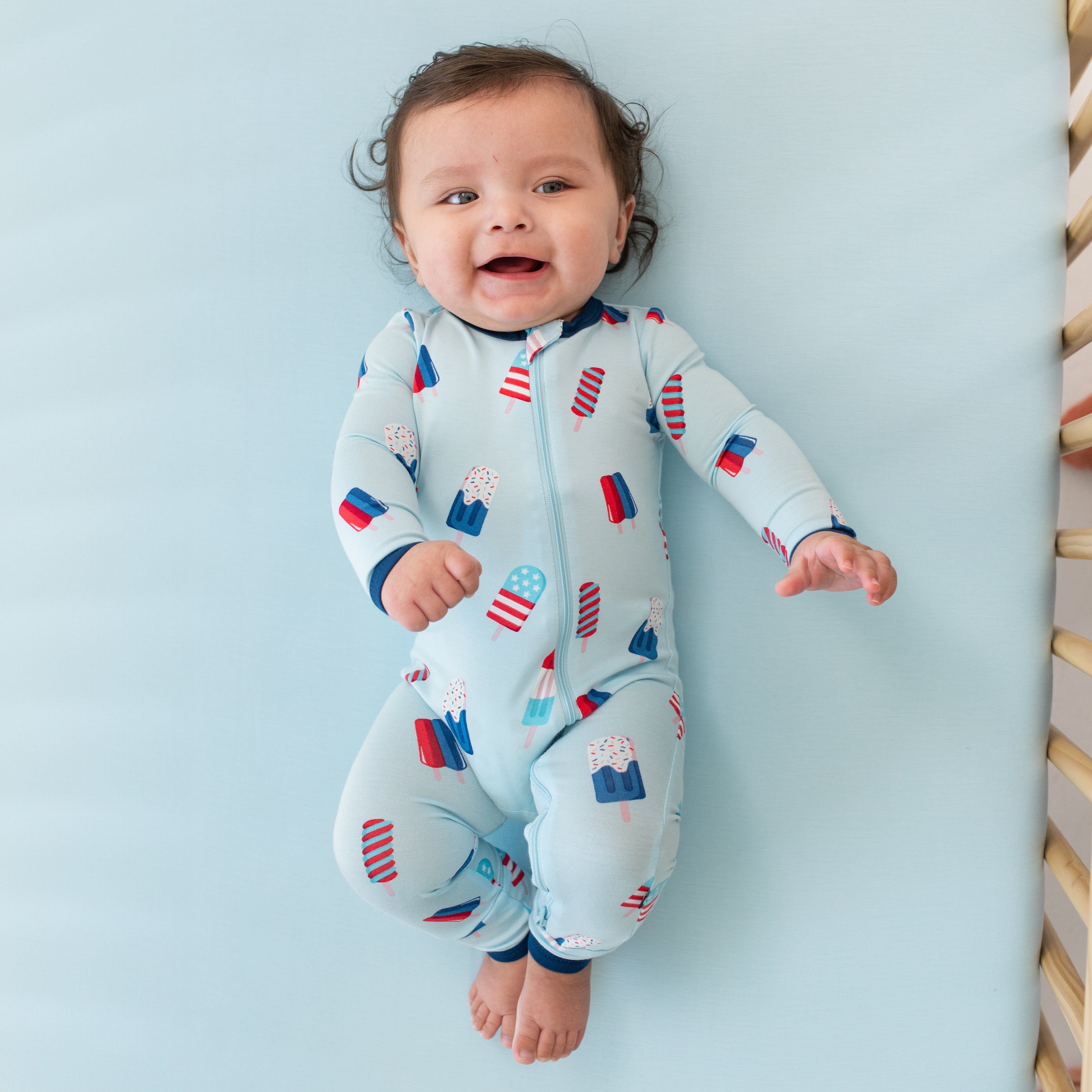 Infant wearing Kyte Baby Zippered Romper in Popsicle