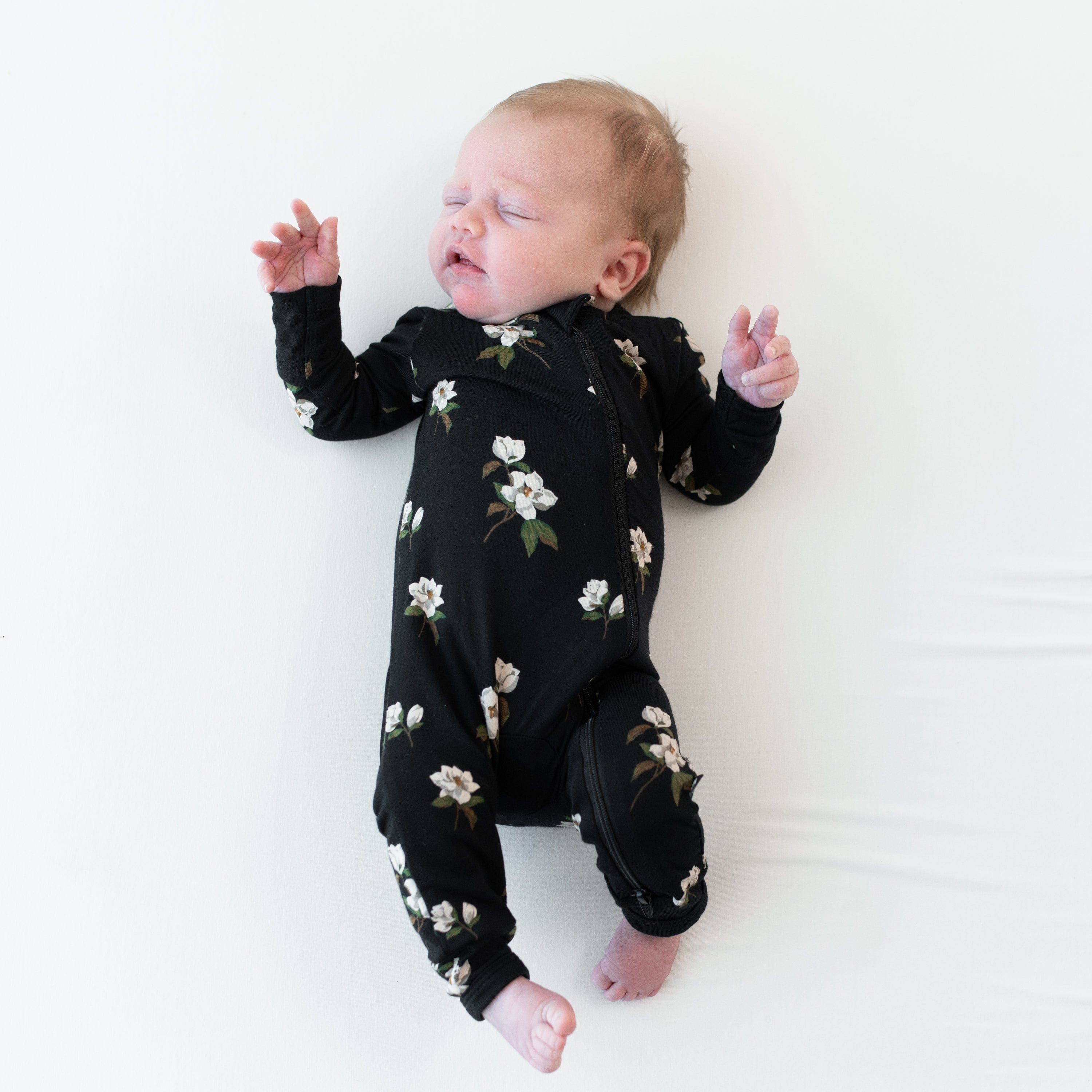 Newborn wearing Kyte Baby Zippered Romper in Small Midnight Magnolia