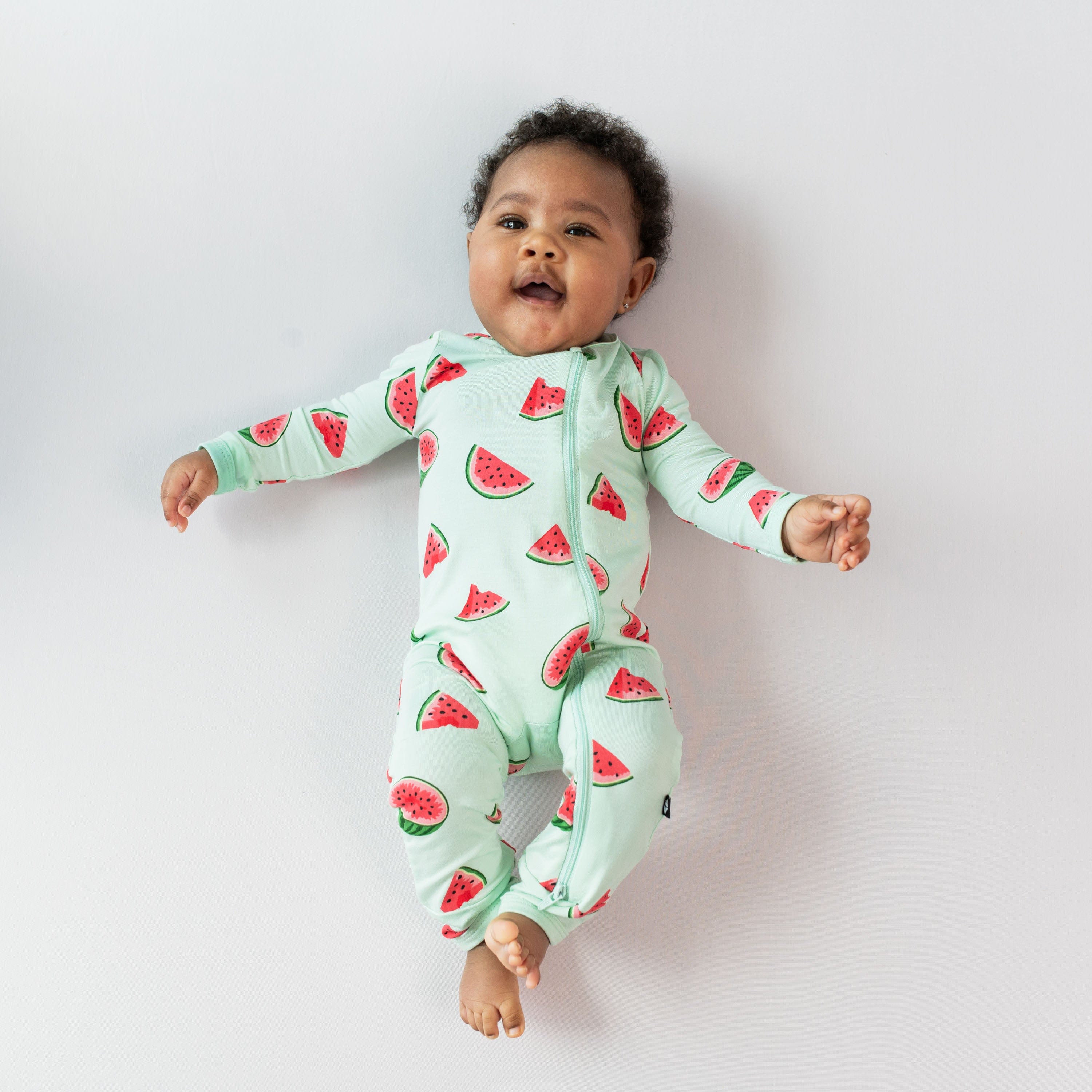 Infant wearing Kyte Baby Zippered Romper in Watermelon