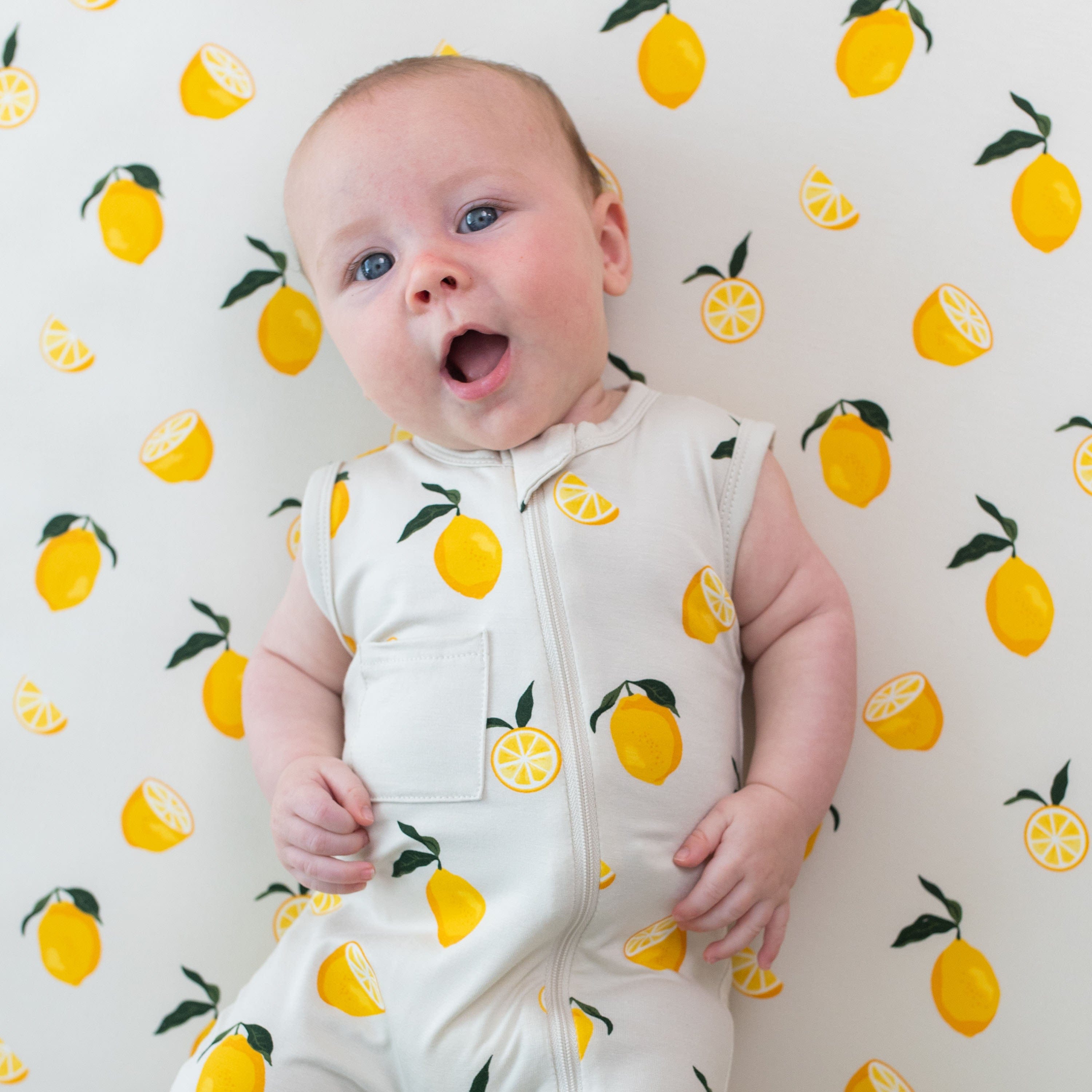 Infant wearing Kyte Baby Zippered Sleeveless Romper in Lemon