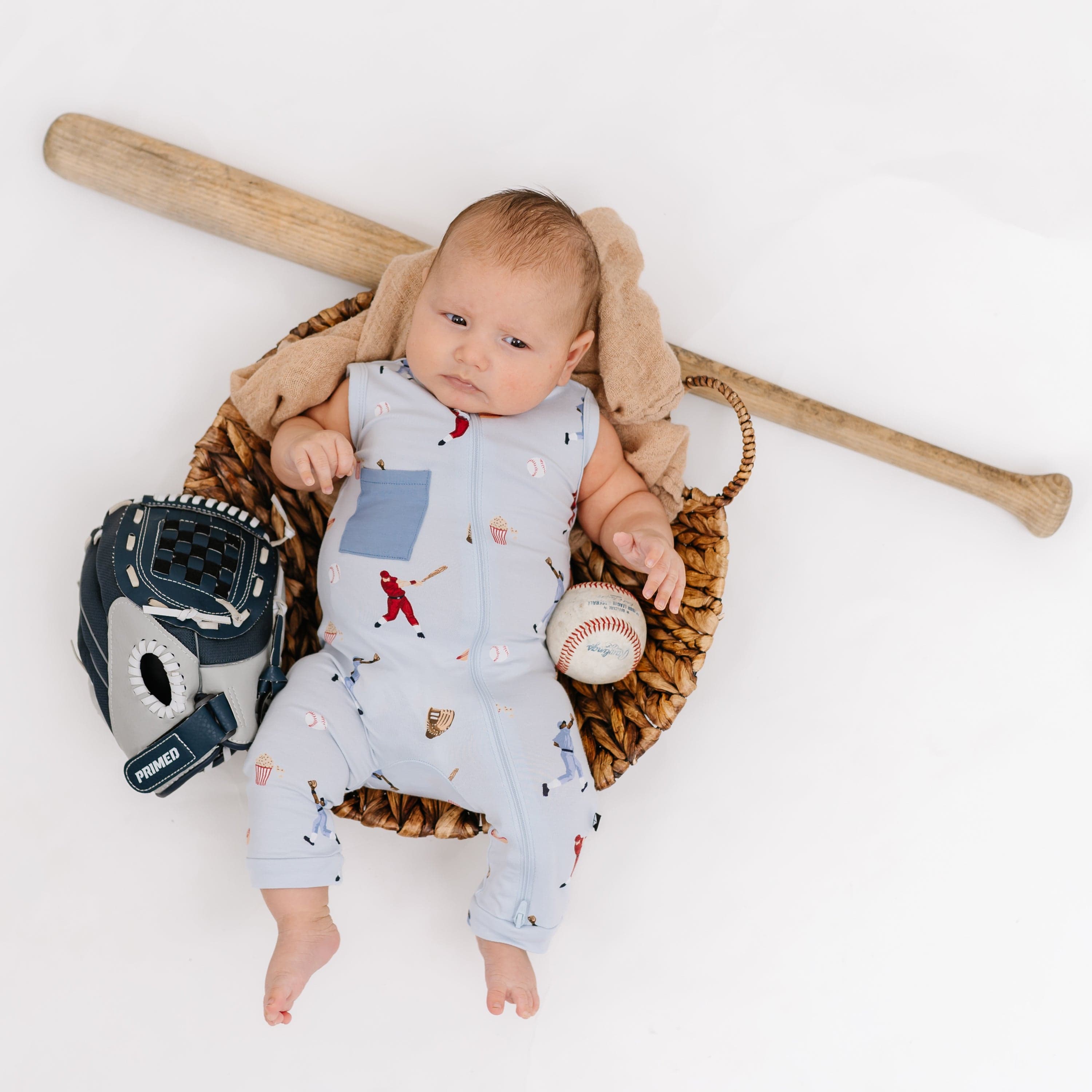 Baby wearing Kyte Baby bamboo Zippered Sleeveless Romper in Vintage Baseball