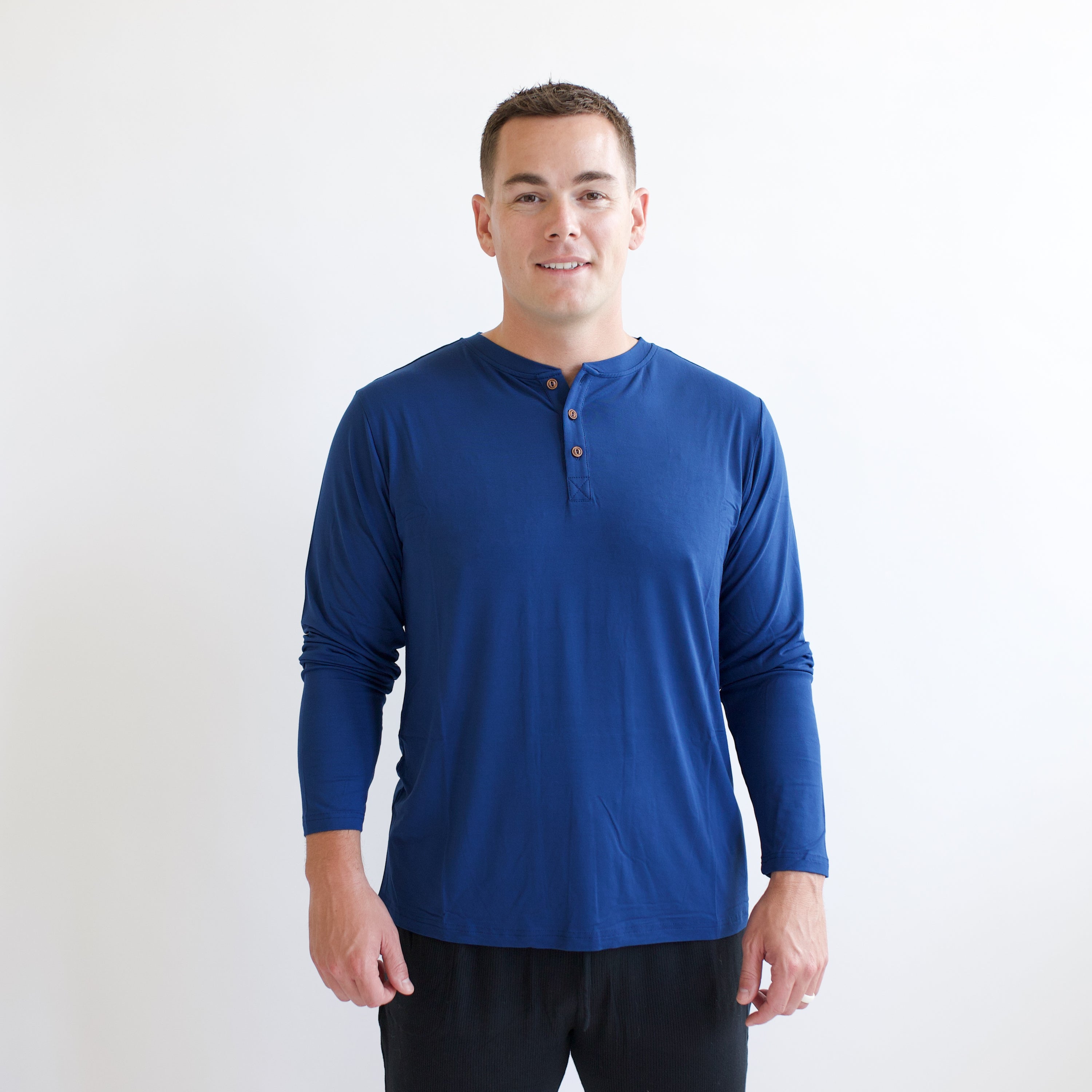 Male model wearing the Men's Long Sleeve Henley Top in Tahoe standing in front of a white backdrop