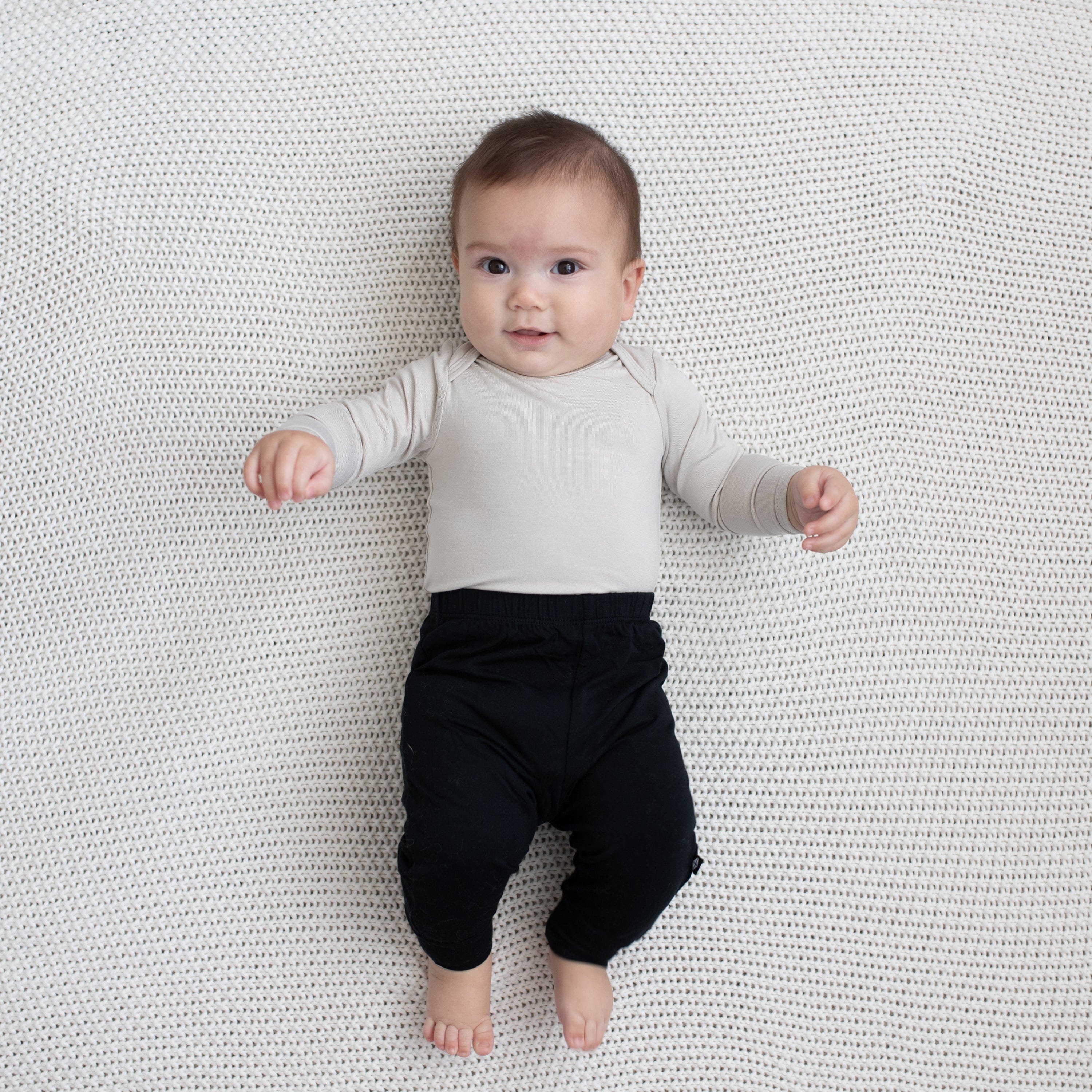 Baby modeling Pant in Midnight and Oat Long Sleeve Bodysuit
