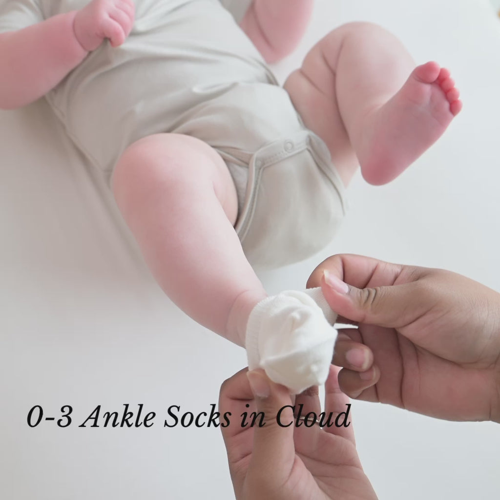 Video of parent putting Kyte Baby Ankle Socks in Cloud white on newborn