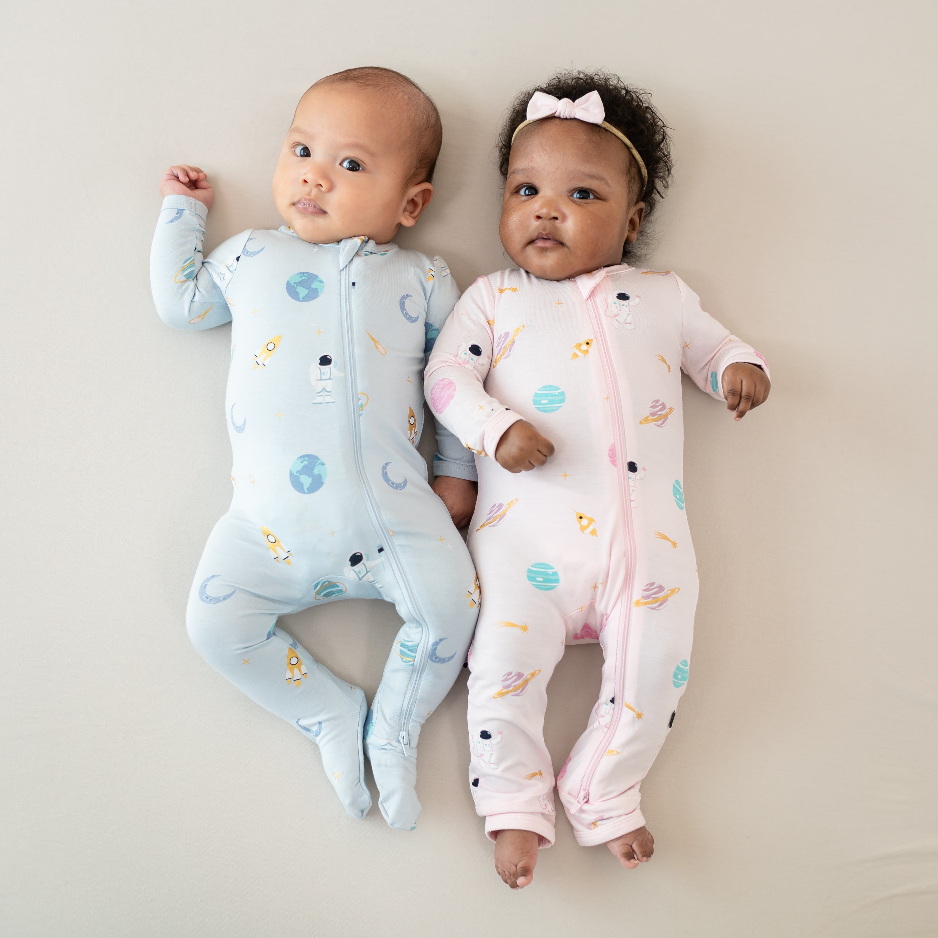 babies wearing zippered footie in ice space and zippered romper in sakura space