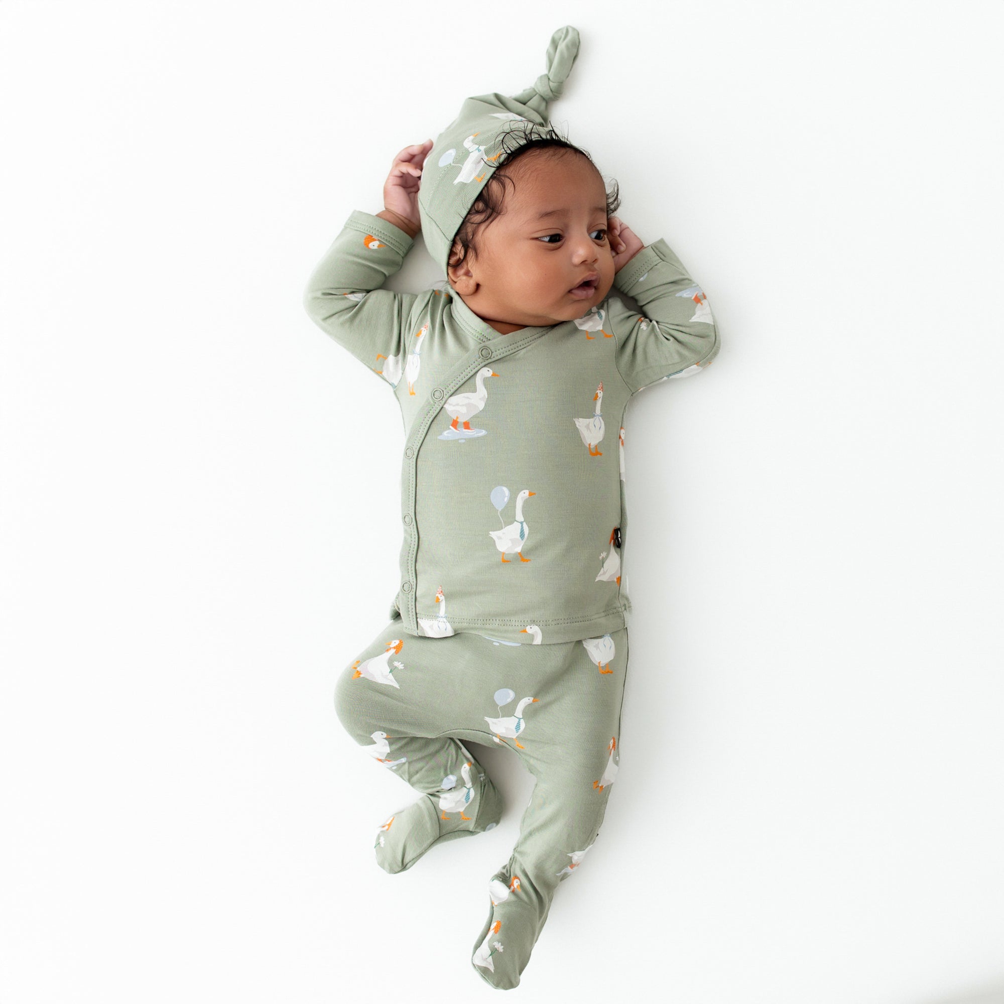 Infant laying on a light neutral background wearing the Take Me Home Set in Silly Goose