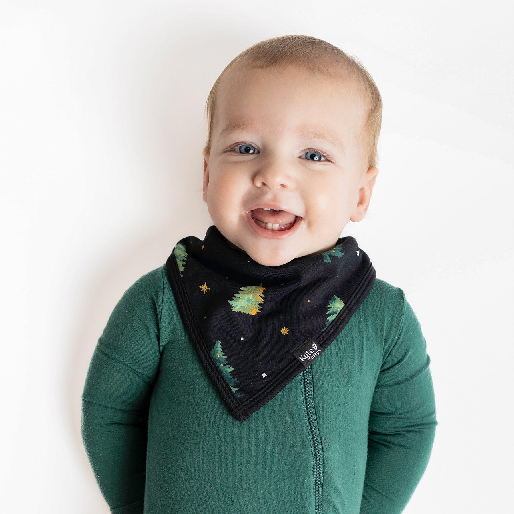 Close up of the Bib in Twinkle Tree on a young toddler wearing an Emerald Zipper Romper