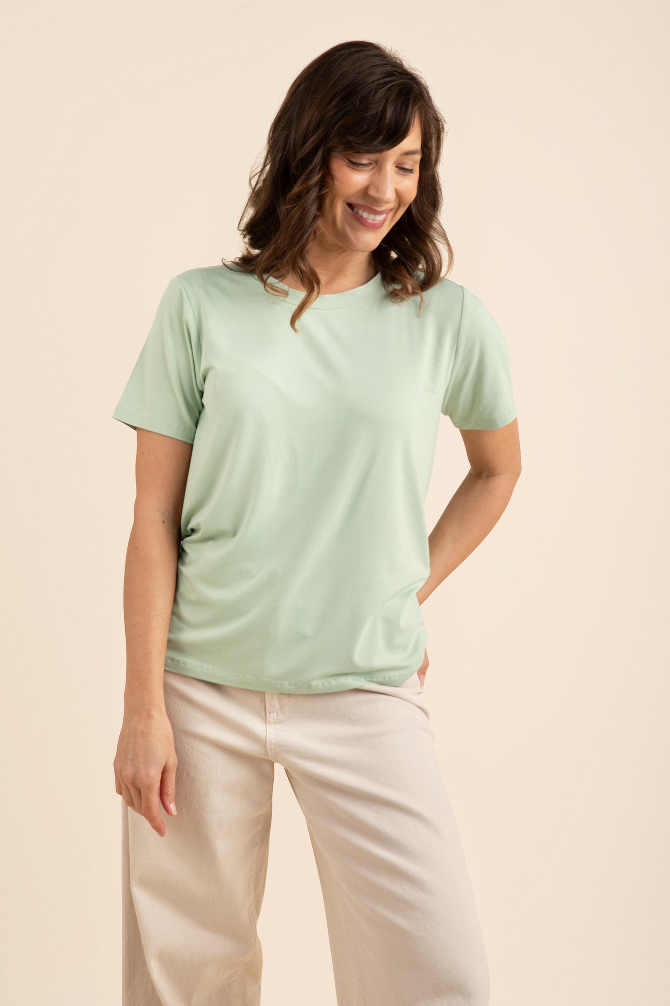 Woman wearing a light green tee and cream pants