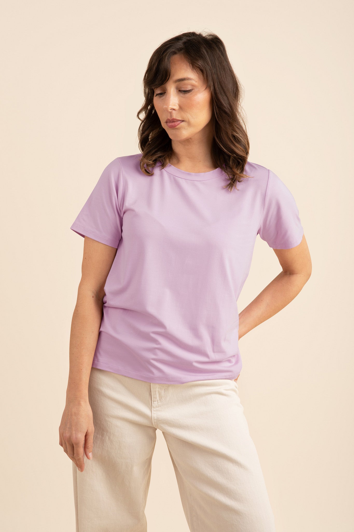 Woman wearing a light purple tee and cream pants
