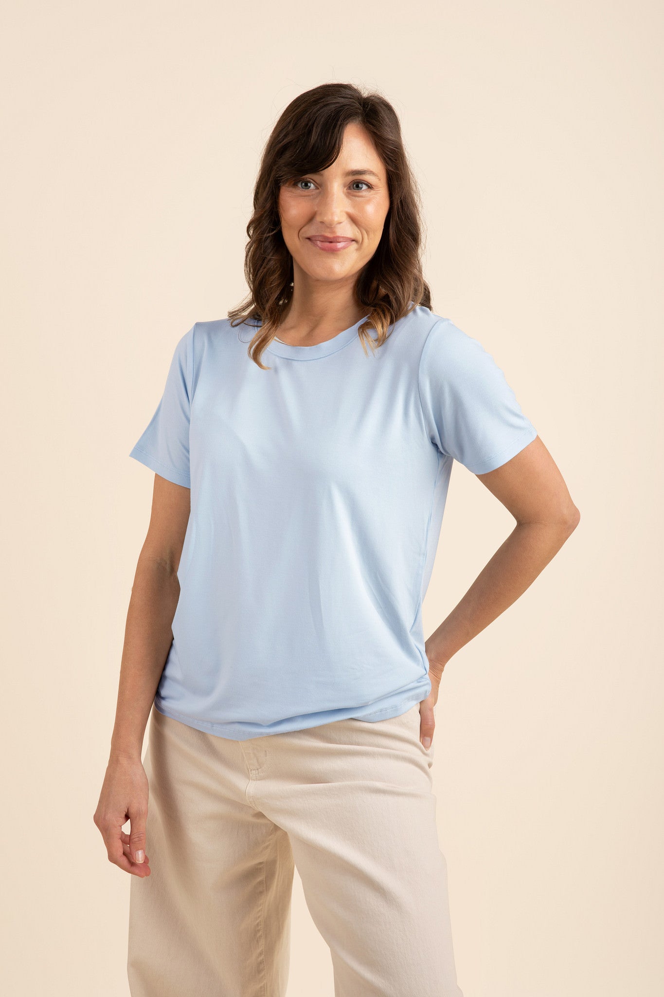 Female modeling the soft and breathable Women's Crew Neck Tee in Breeze paired with light beige pants