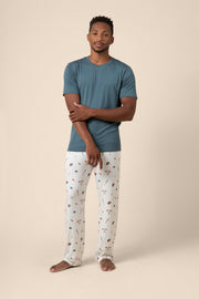 Man wearing a blue t-shirt and baseball patterned pants on a beige background