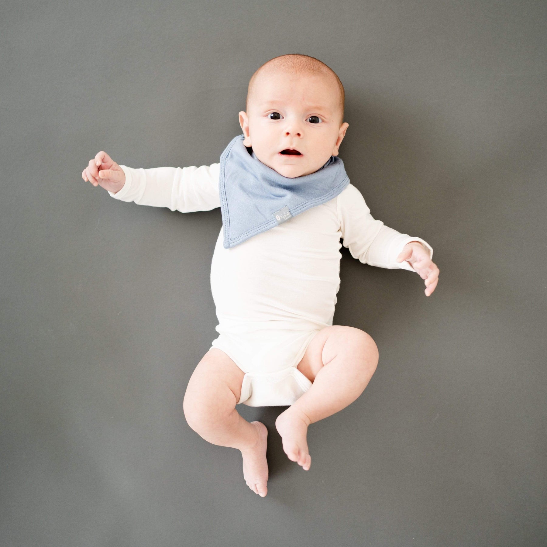 Infant wearing Kyte Baby Bib in Slate