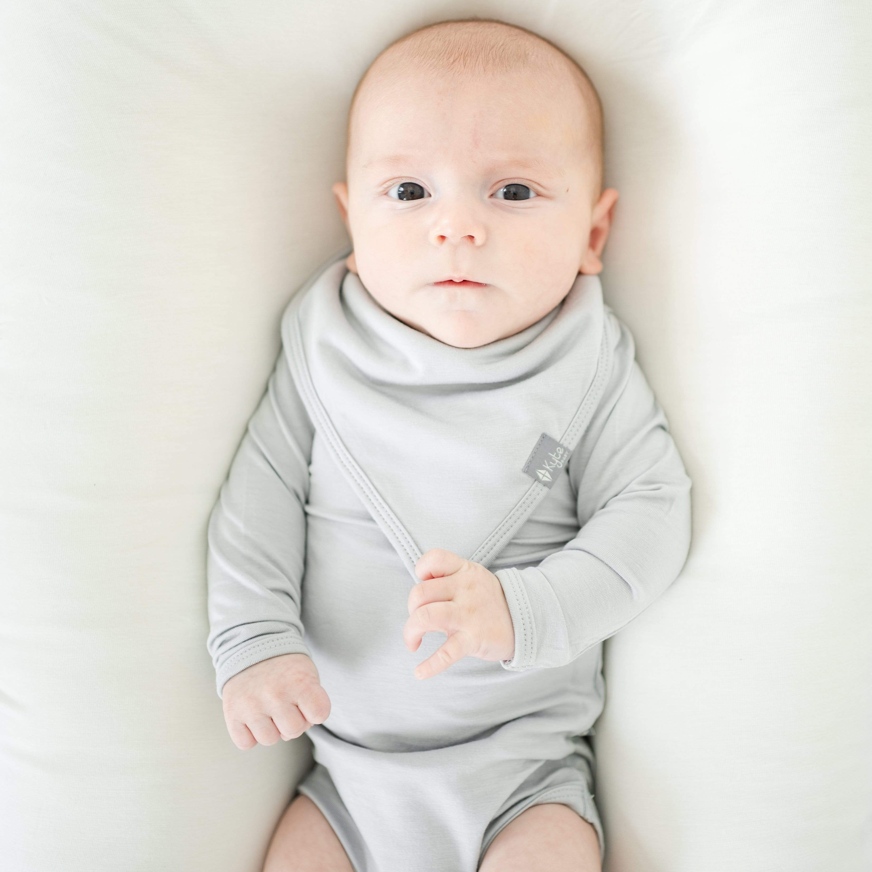 Infant wearing Kyte Baby Bib in Storm gray