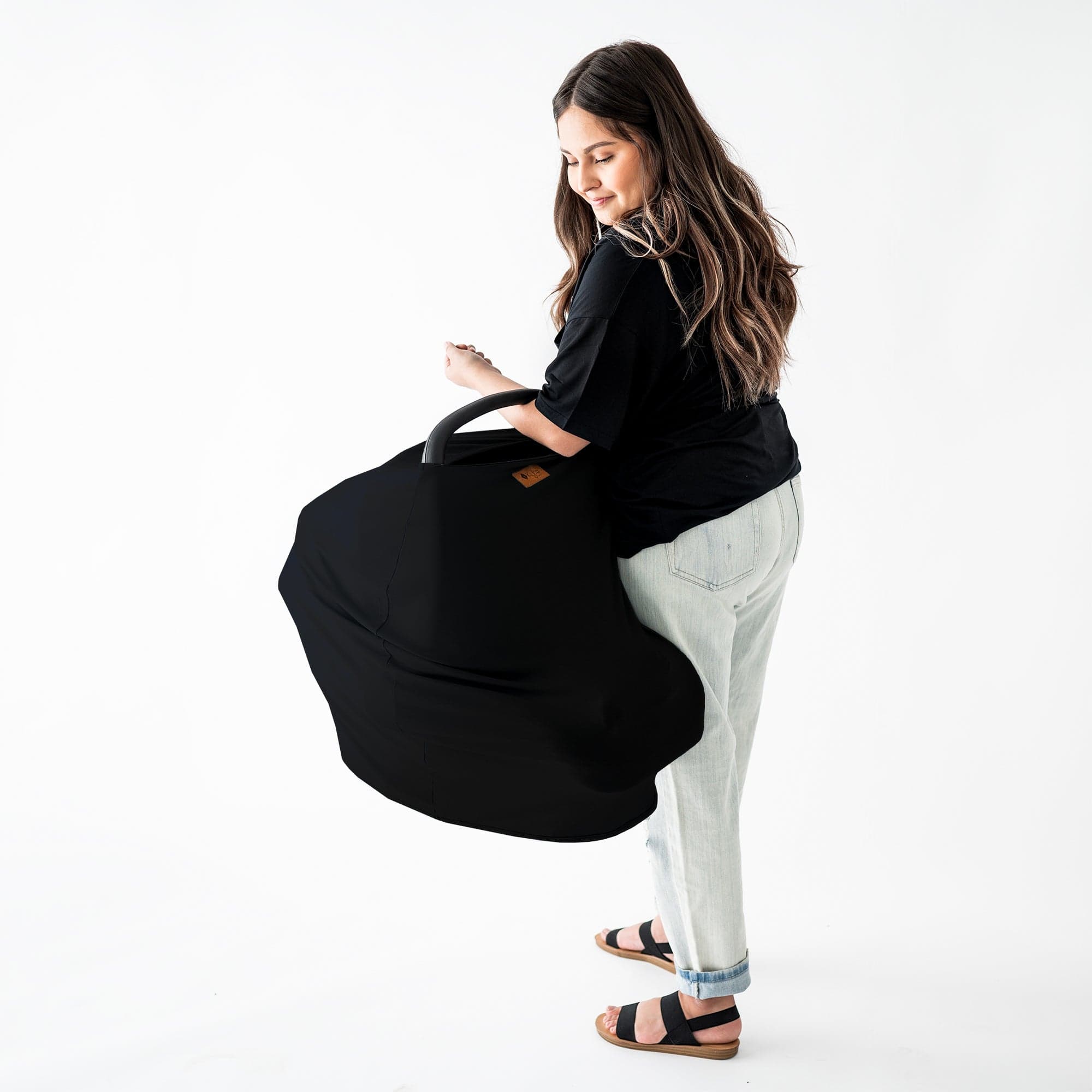 Mom carrying infant seat with Kyte Baby Car Seat Cover in Midnight