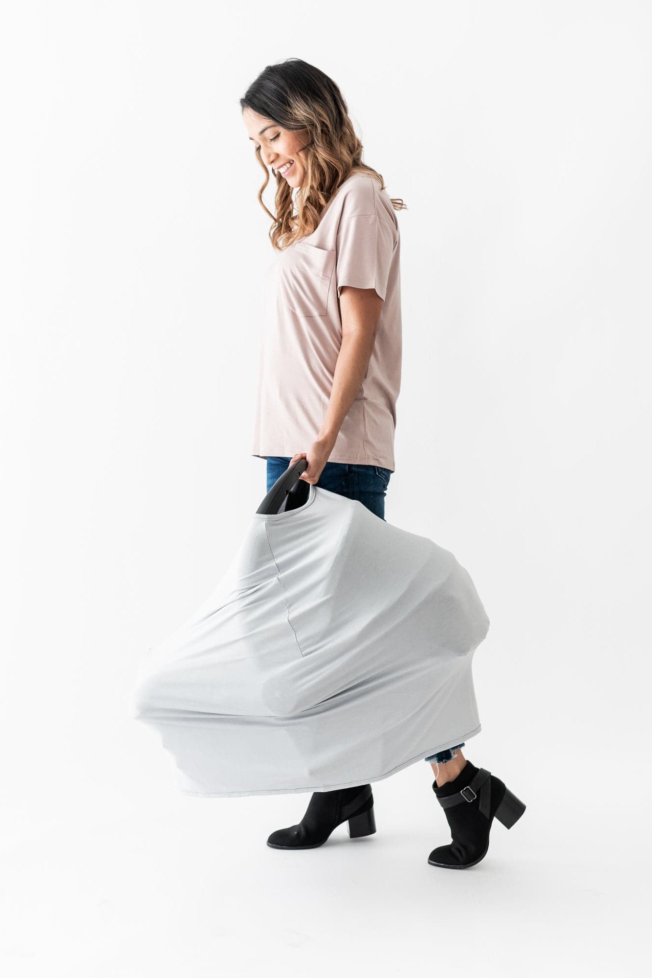 Mom carrying baby car seat with Kyte Baby carseat and nursing cover in Storm