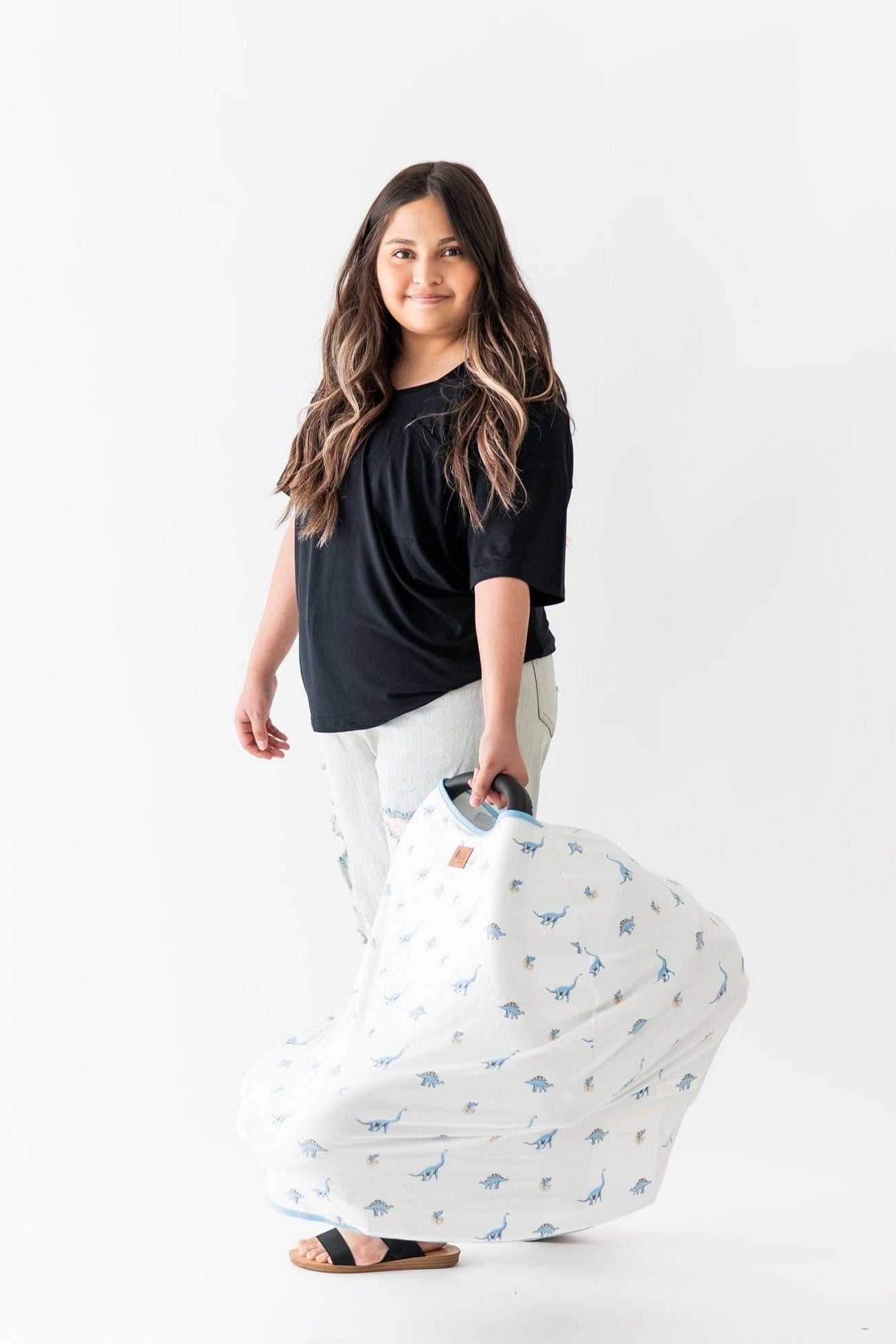 Woman carring carseat with Kyte Baby 3-in-1 Car Seat Cover in Jurassic