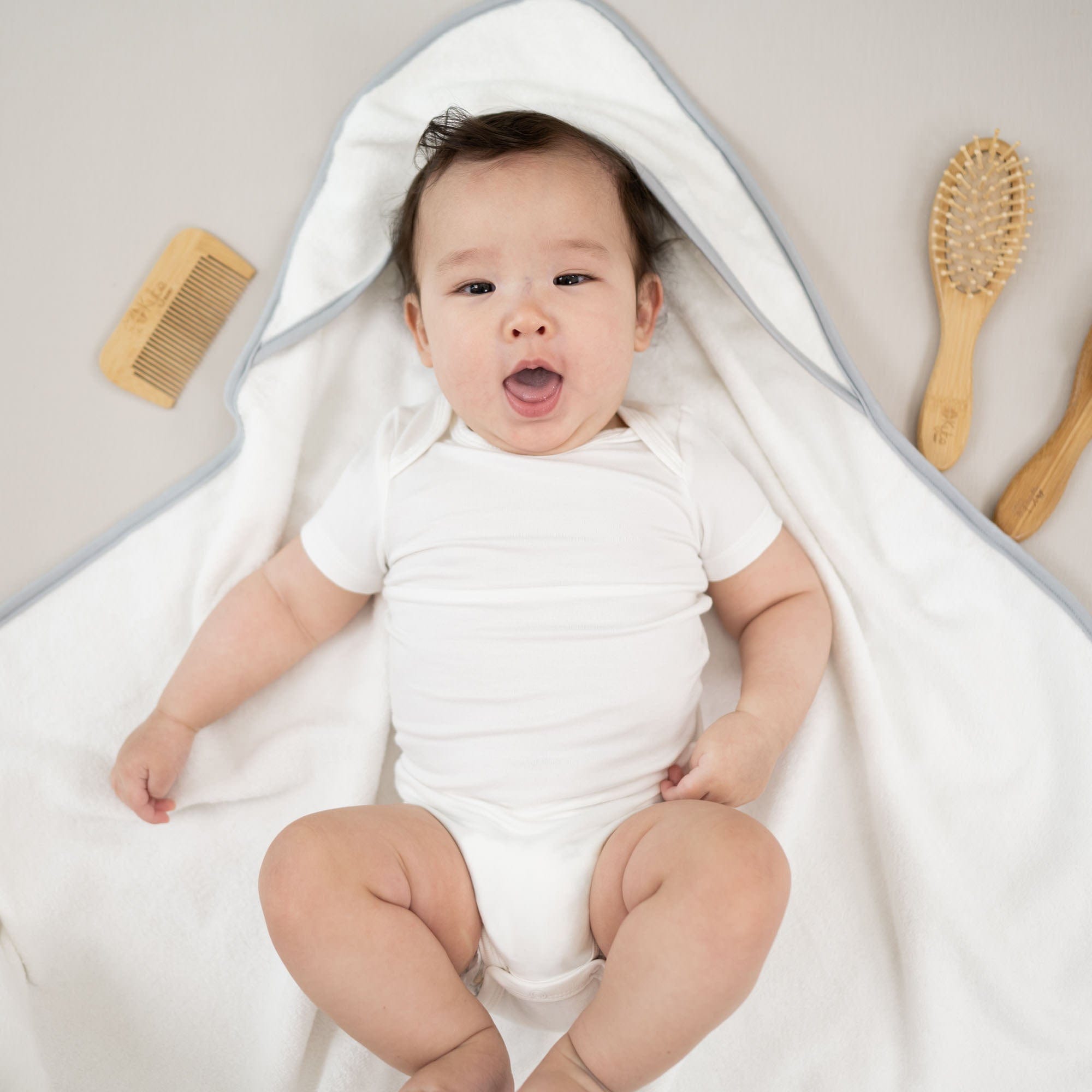 Kyte Baby Home and Bath 3-Piece Brush Set with Infant in Hooded Towel