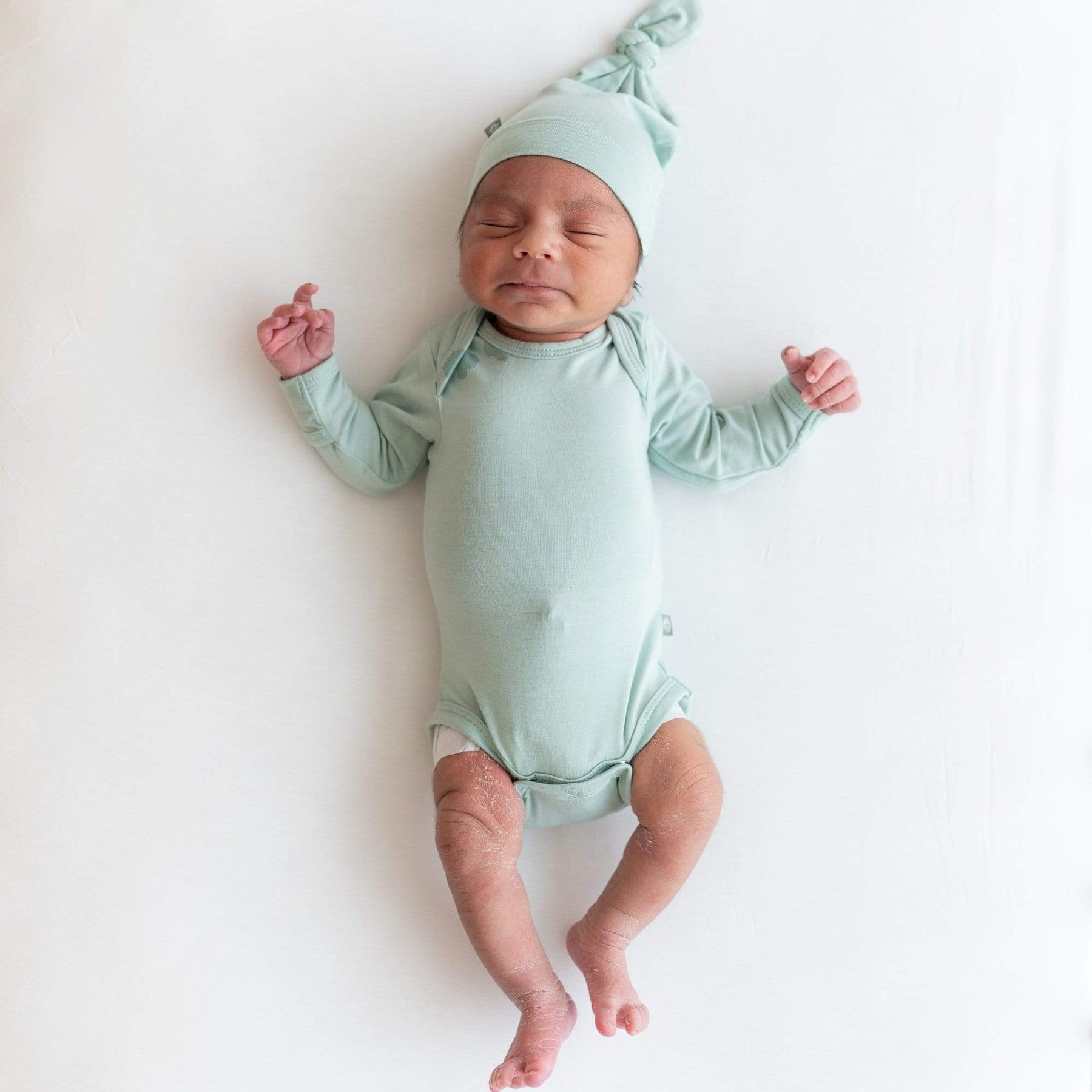 Newborn wearing Kyte Baby Long Sleeve Bodysuit in Sage