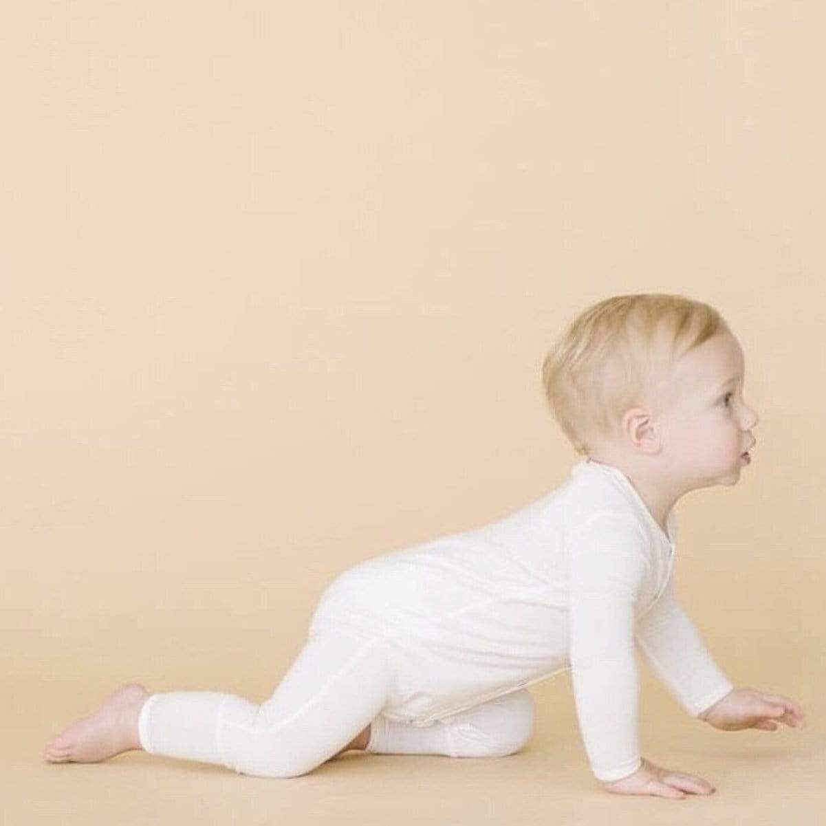 Infant crawling in Kyte Baby Romper in Cloud