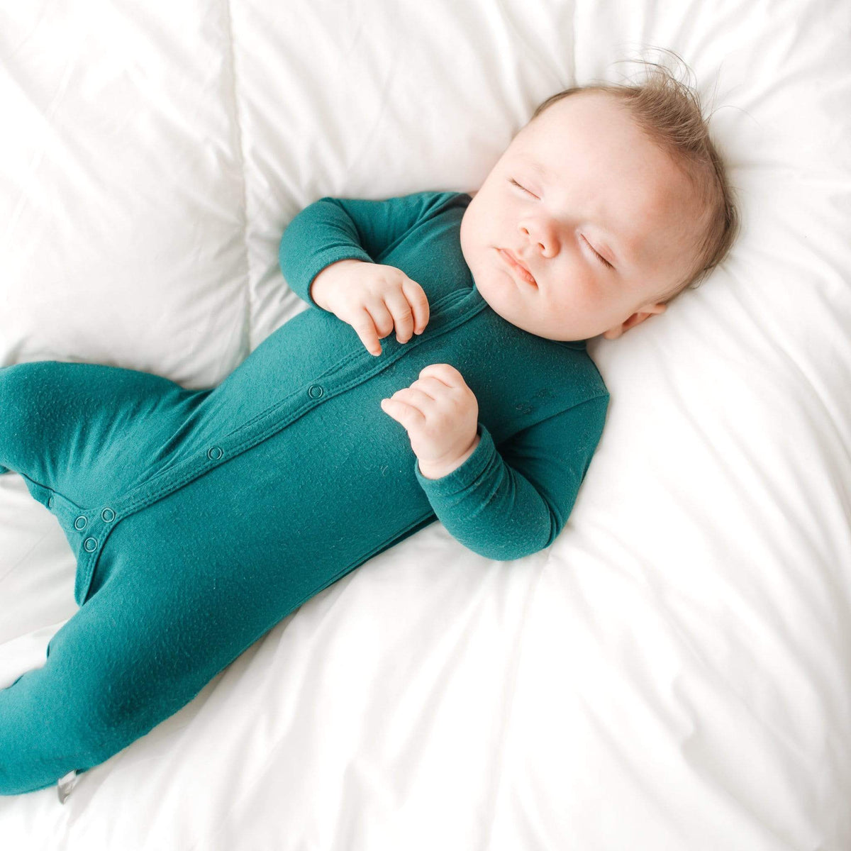 Infant sleeping in Kyte Baby Romper in Emerald