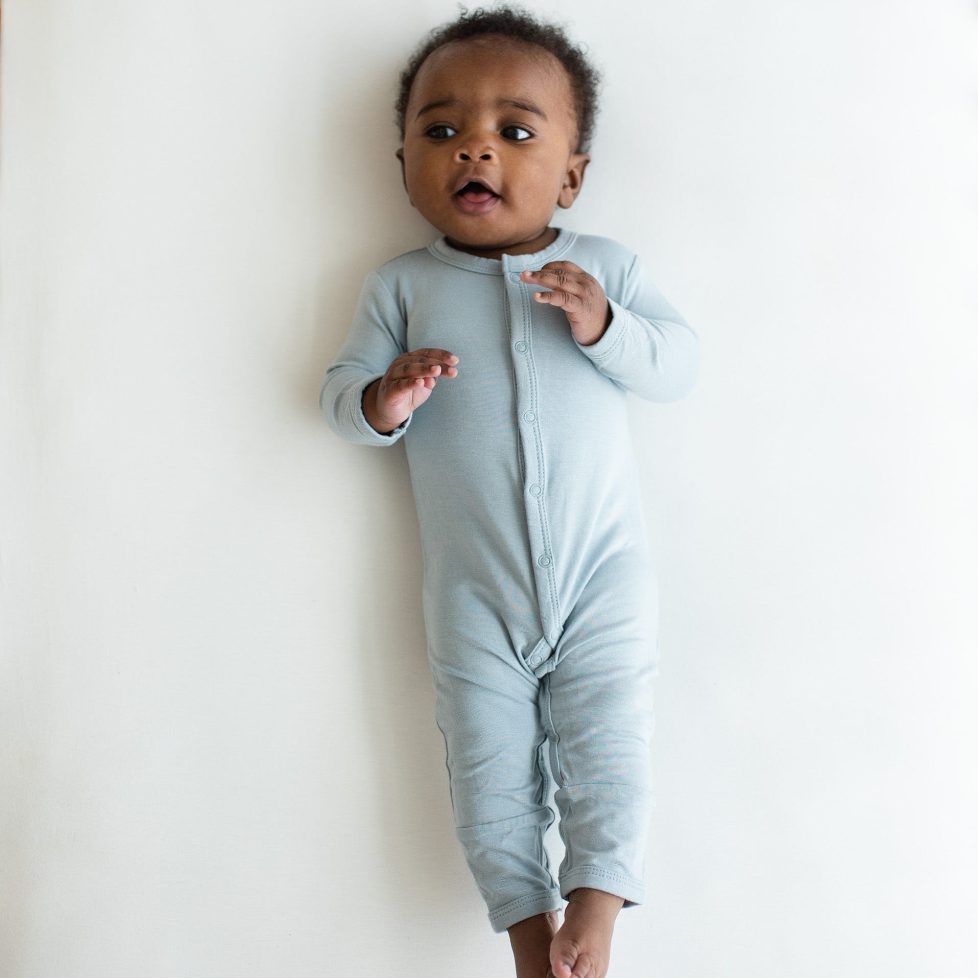 Infant wearing Kyte Baby Romper in Fog